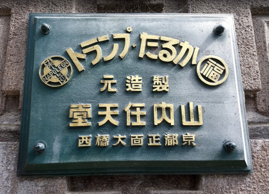 任天堂舊本社門口牌匾，門口兩側一側為日文漢字，另一側為英文。