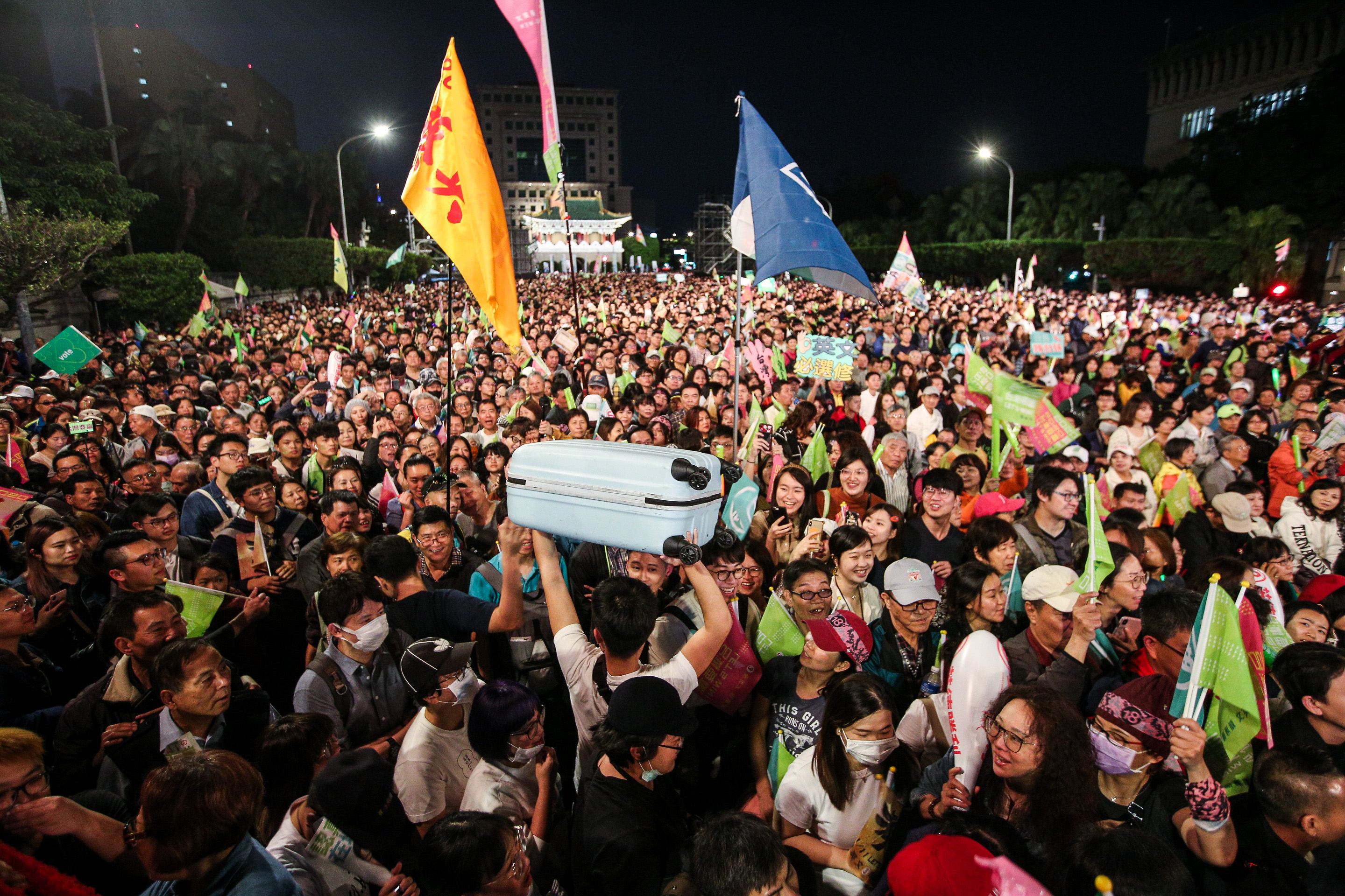 選前的最後一夜，有民眾帶著行李箱前往支持的候選人造勢場合力挺，之後還要趕車回家投票。