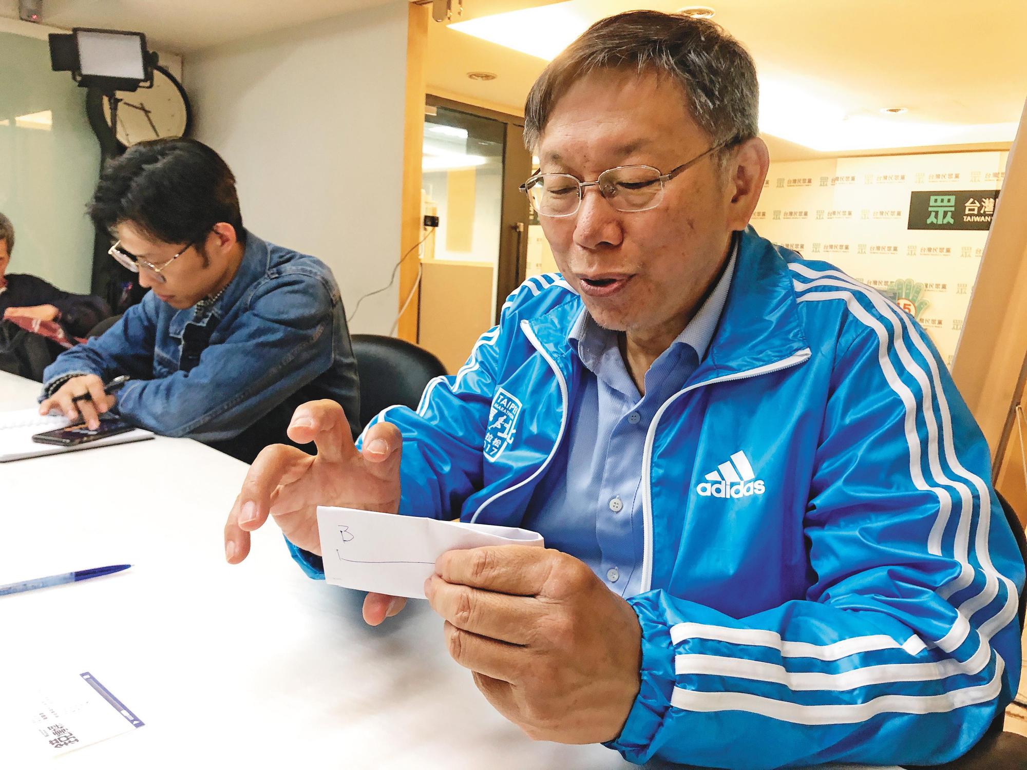 柯文哲接受本刊採訪,拿出紙筆又畫又摺,批評位於統獨軸線兩端的藍綠兩黨其實一丘之貉。