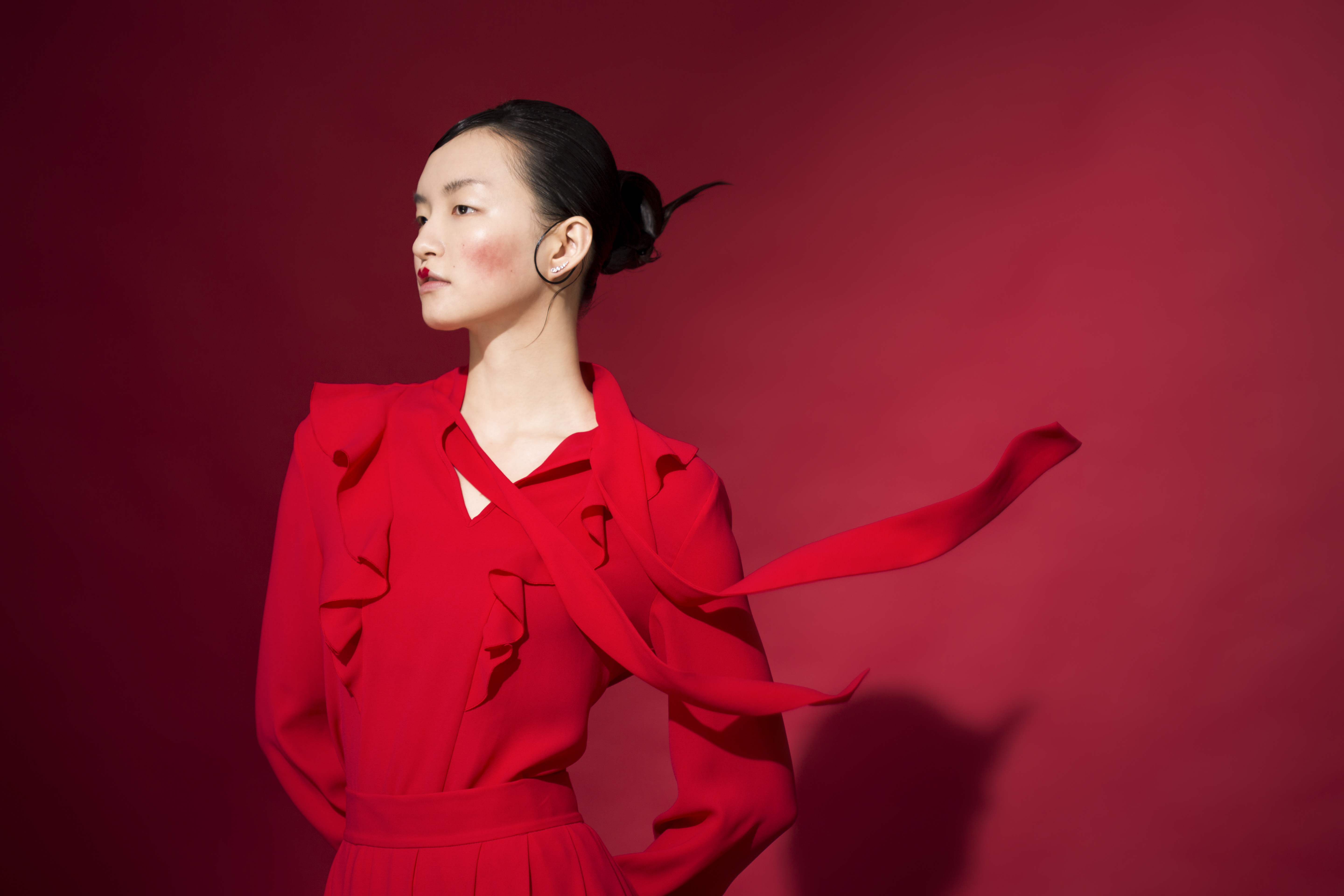 紅色荷葉邊領結襯衫 價格店洽 by MULBERRY MOONSUN／紅色過膝裙 價格店洽 by MULBERRY MOONSUN／穿孔耳環 NT$4,490 by SWAROVSKI