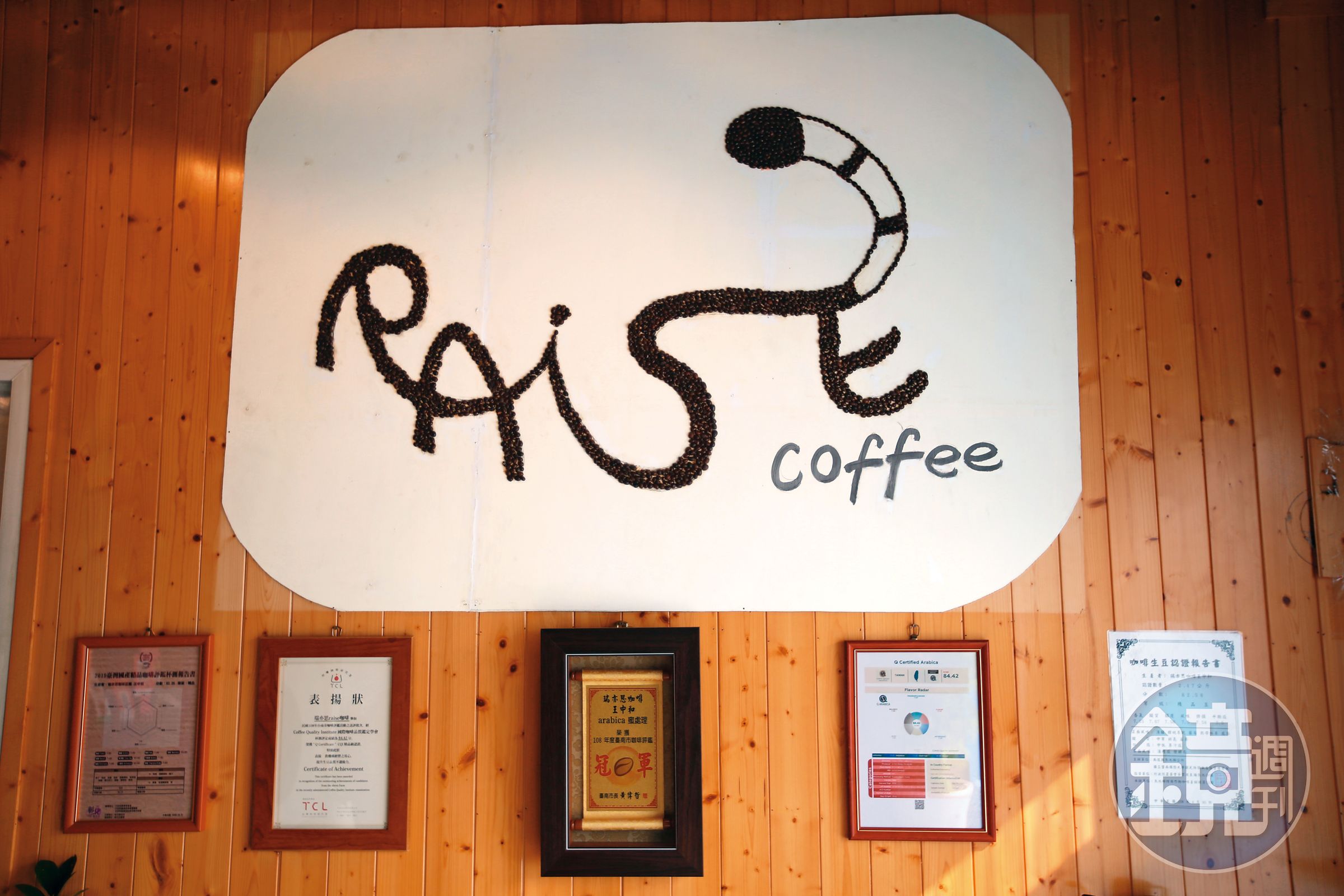店內用咖啡豆拼出的「Raise」招牌，以貓的意象串連整個英文字。