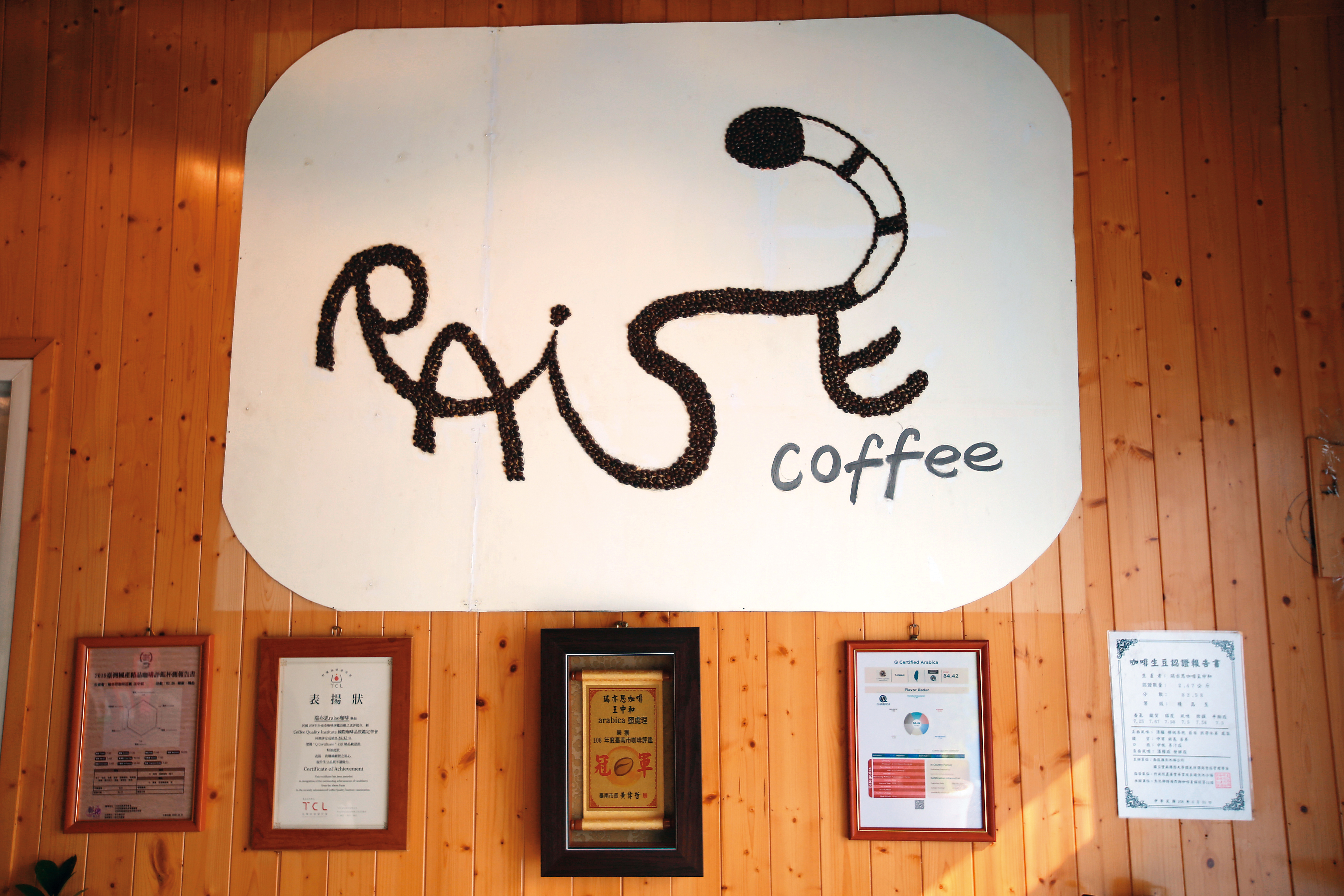 店內用咖啡豆拼出的「Raise」招牌，以貓的意象串連整個英文字。