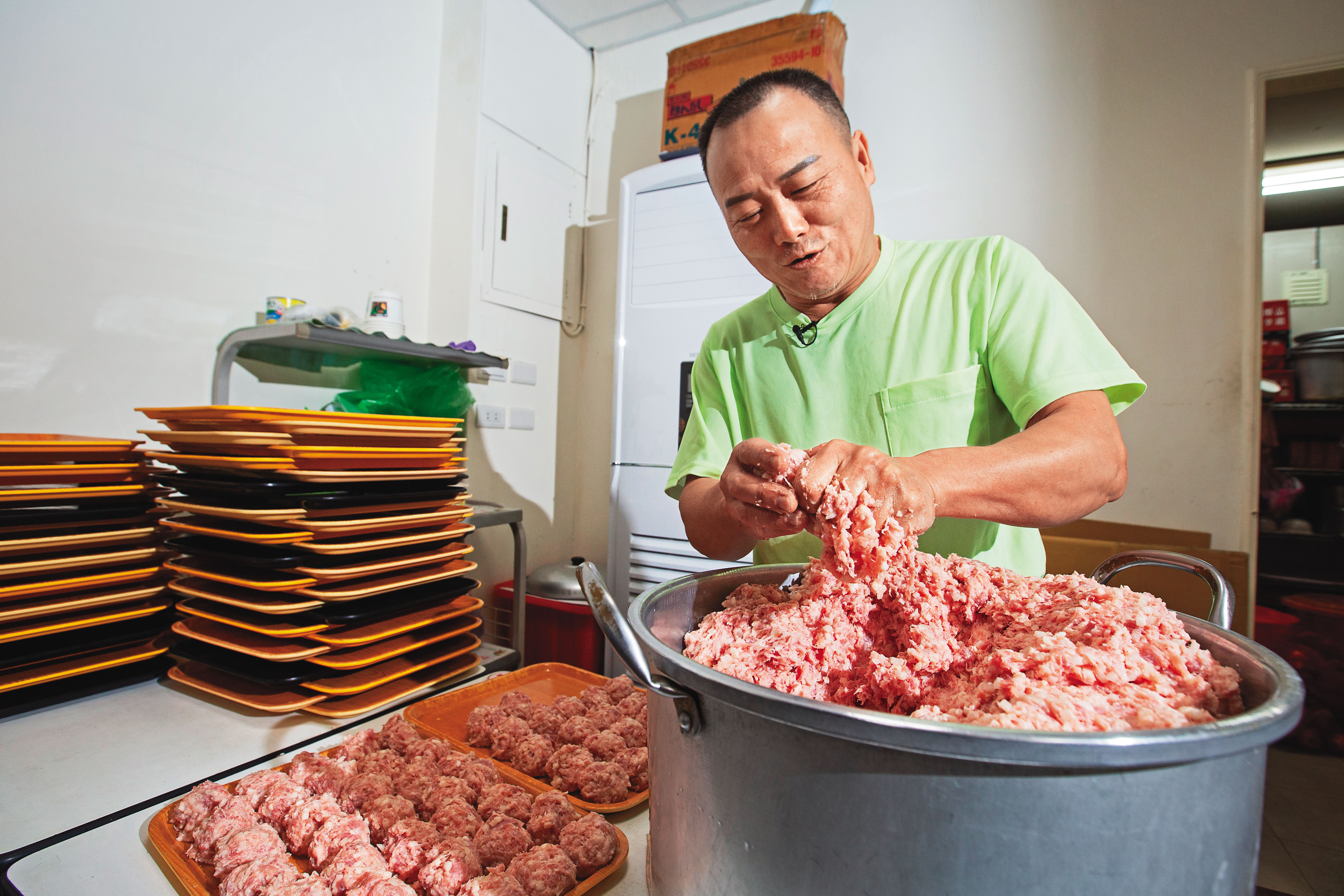 製作獅子頭相當費工，馮坤志以1秒1顆速度從虎口擠出肉丸，再搓圓塑形。