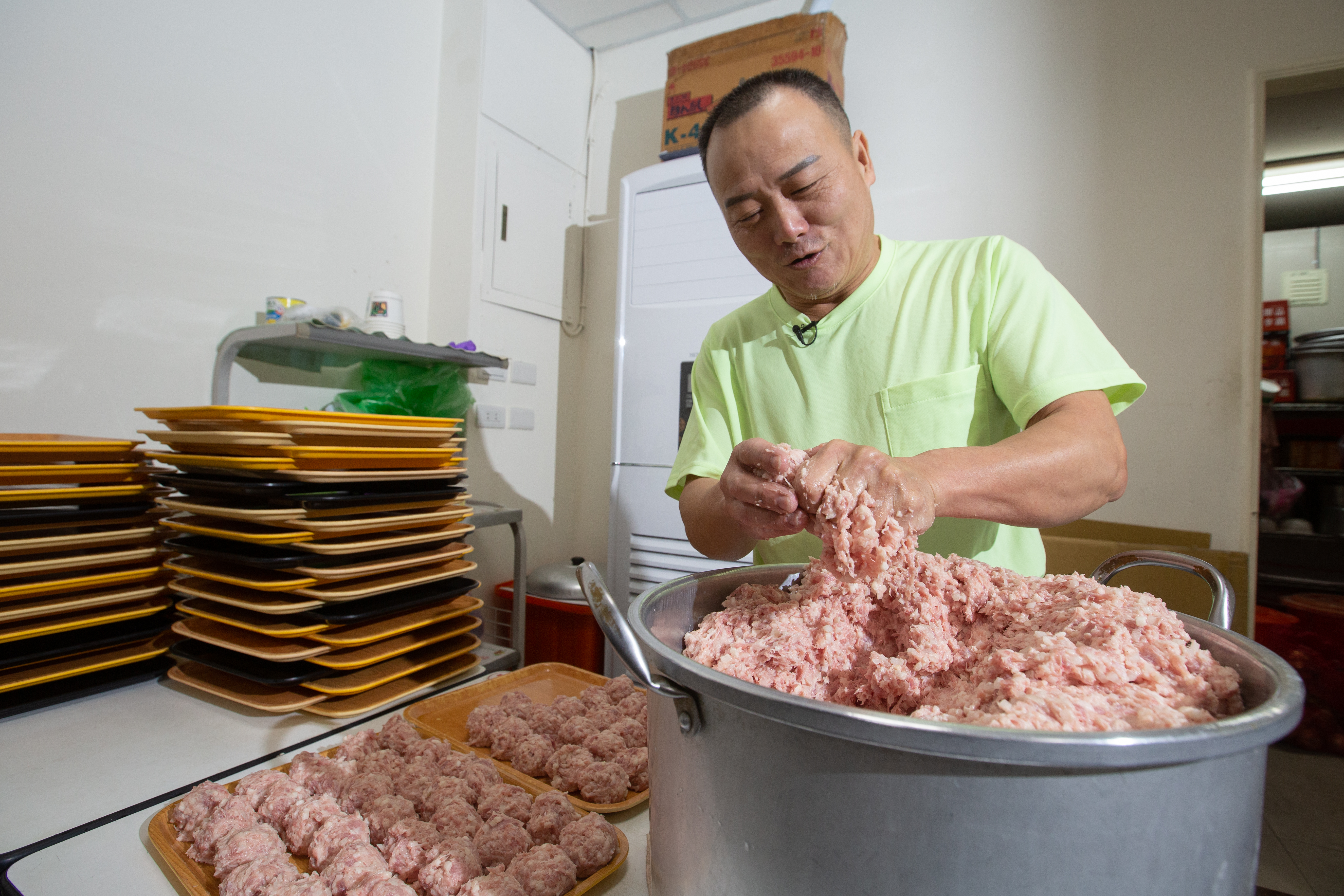 製作獅子頭相當費工，馮坤志以1秒1顆速度從虎口擠出肉丸，再搓圓塑形。