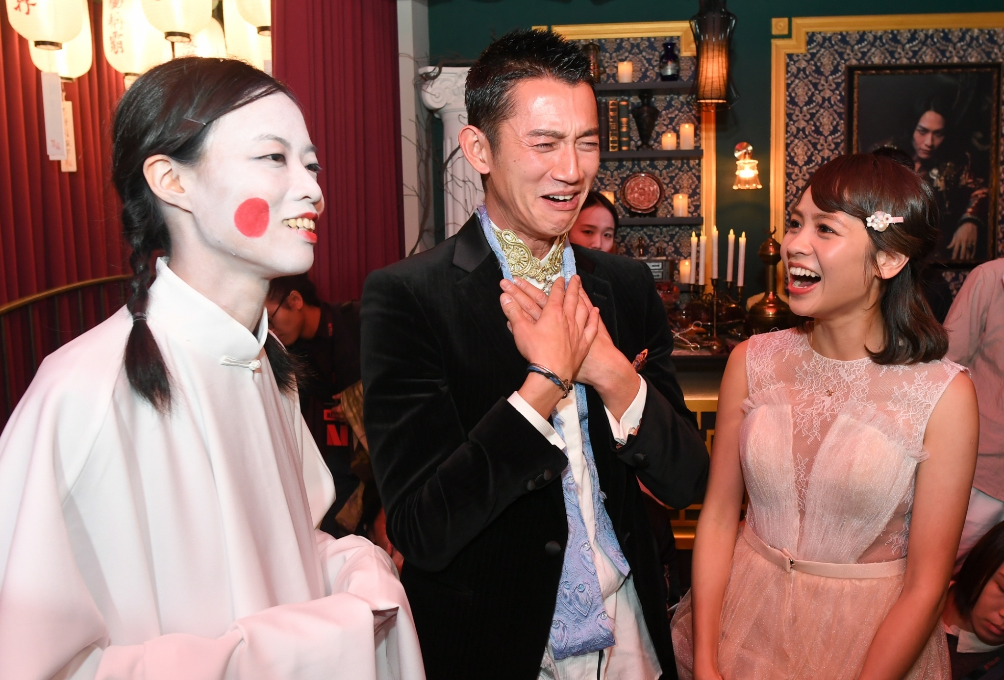 吳慷仁(中)、黃姵嘉(右)參觀在華山特區舉辦的「《彼岸之嫁》麗蘭的婚禮」特展,遇到「金童玉女」打扮的導覽員。(Netflix提供)