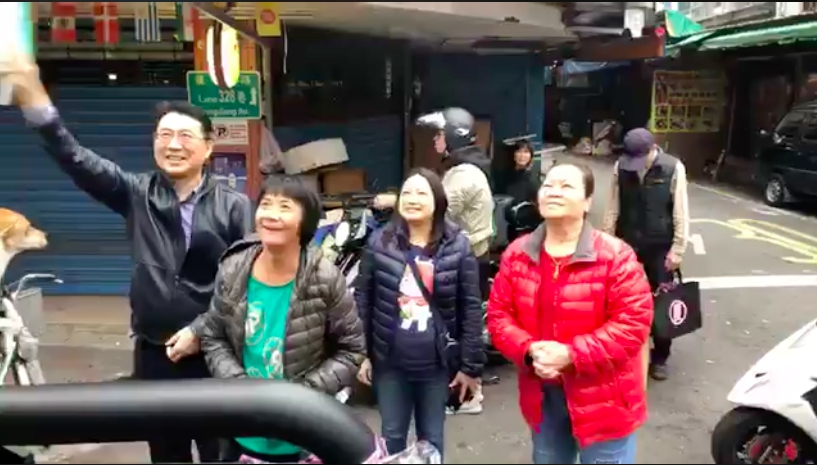 和吳怡農握手後，阿伯一人落在人群後方落淚。（翻攝自吳怡農粉絲專頁）