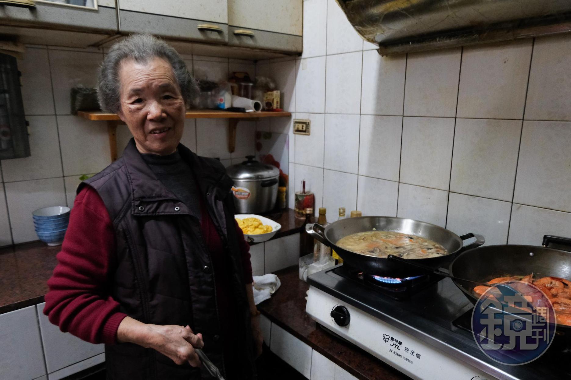 年屆八旬的周家奶奶身子硬朗地炒年糕。