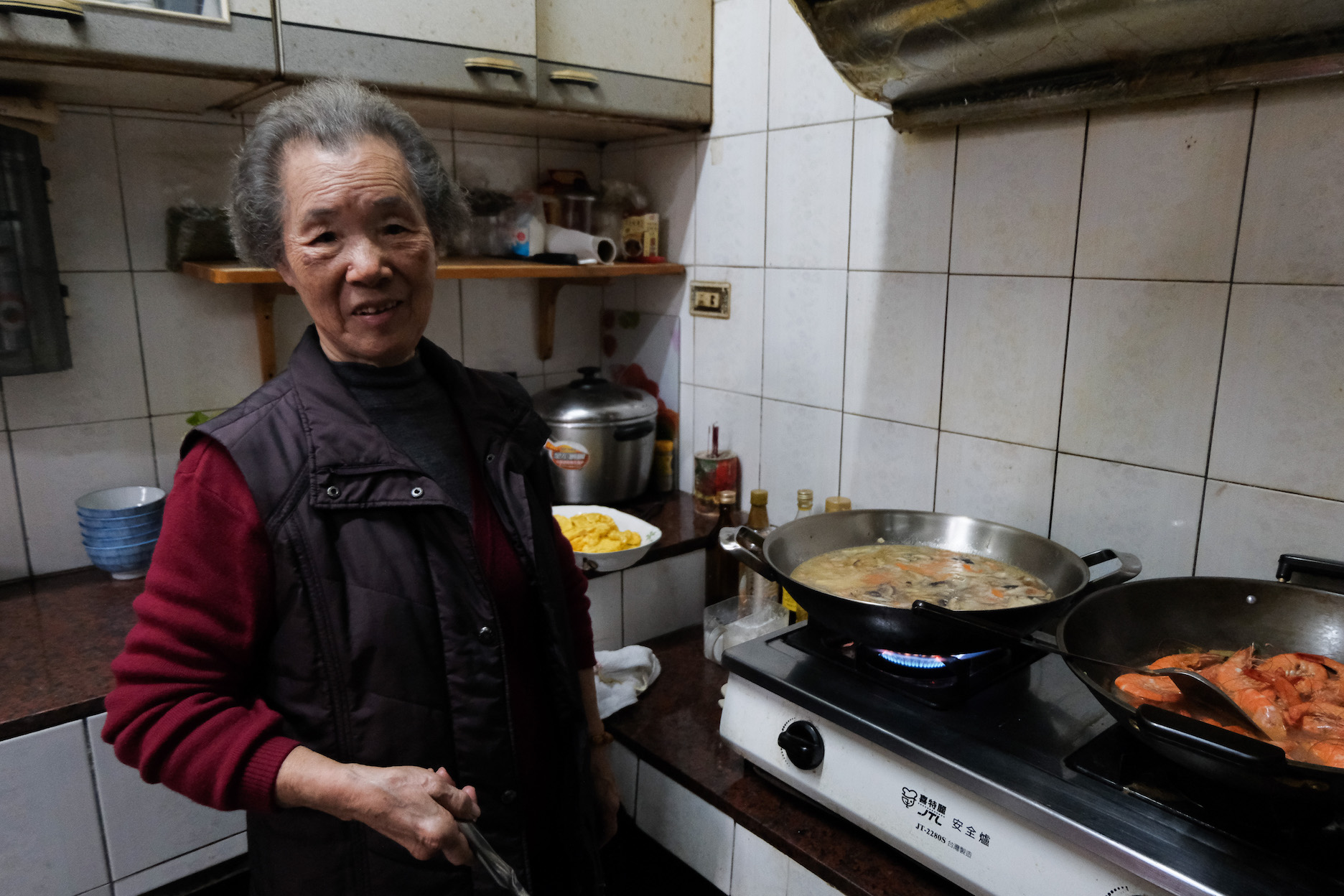 年屆八旬的周家奶奶身子硬朗地炒年糕。