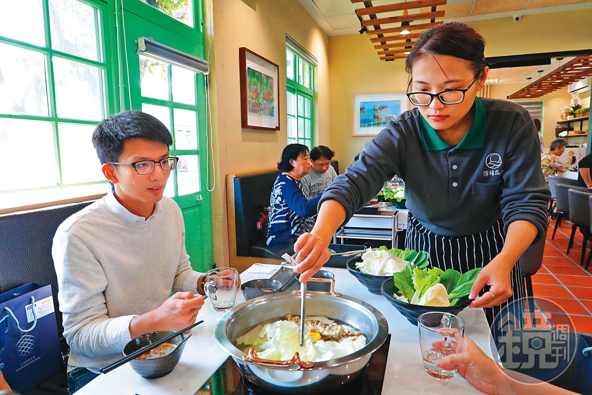 「及水火鍋館」服務人員細心幫客人將食材放入火鍋。