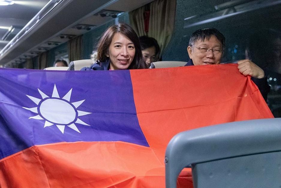 柯文哲出訪拉脫維亞,在里加機場與手持國旗的觀傳局公費留學生合照。(翻攝自柯文哲粉絲專頁)