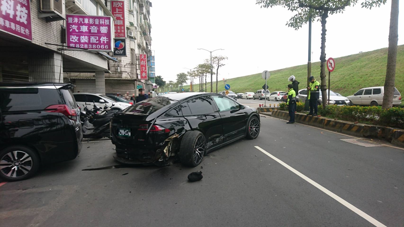 特斯拉轎車在發生撞擊車禍後,後保桿及輪胎均脫落。(翻攝畫面)