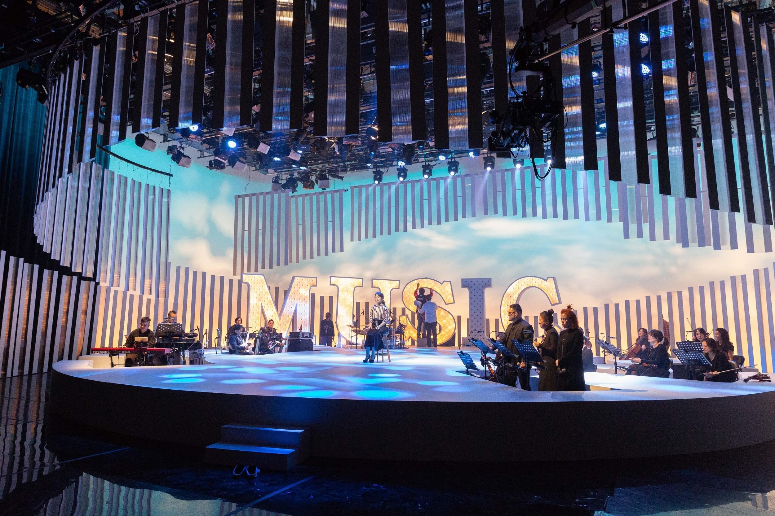 白色舞台的投影效果，以及管、弦、搖滾樂團編制，可隨節目挑選不同曲目變幻風格。