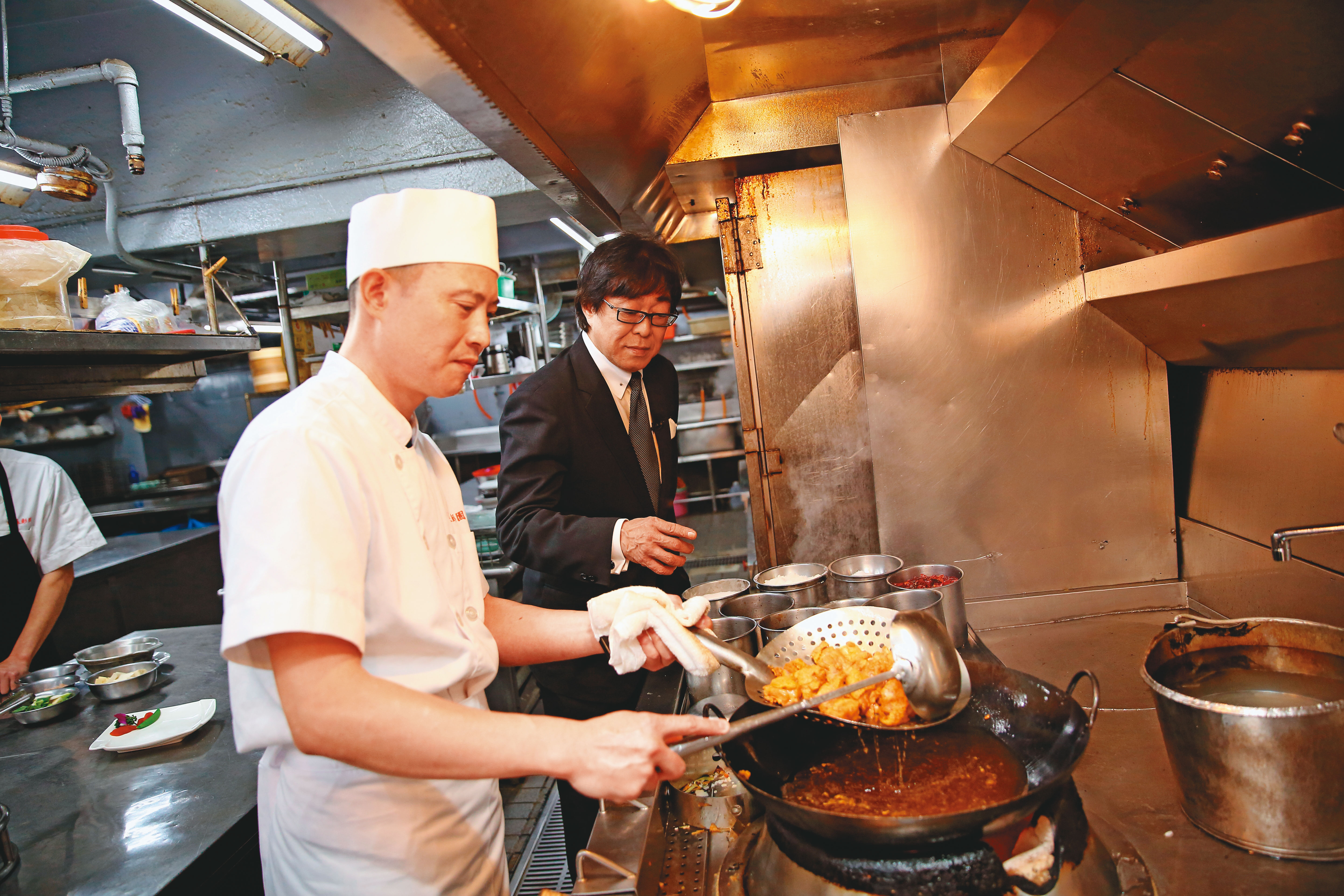 彭鐵誠（後）每天都在自家餐廳用餐，若覺得味道有偏，會特意進廚房了解狀況。