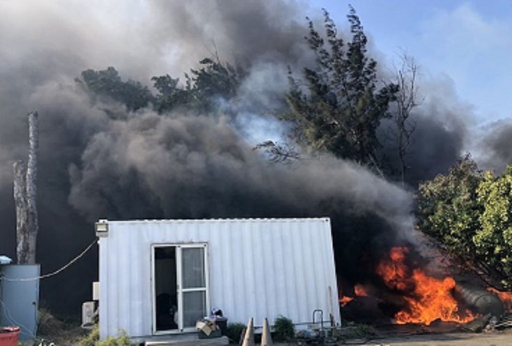 空地堆置大批廢塑膠料，起火燃燒，黑煙直竄，漫天煙霧。（翻攝畫面）