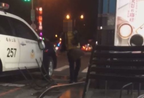 高男不滿警方沒有立刻調閱到監視器，持鐵椅砸警車。（讀者提供）