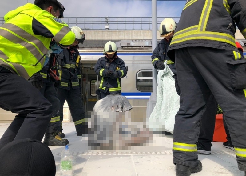今天下午一名男子在台鐵烏日站爬上區間車車廂，遭電擊摔落月台，全身衣服燒破，四肢明顯出現燒傷，消防人員抵達前仍意識清楚。（翻攝畫面）