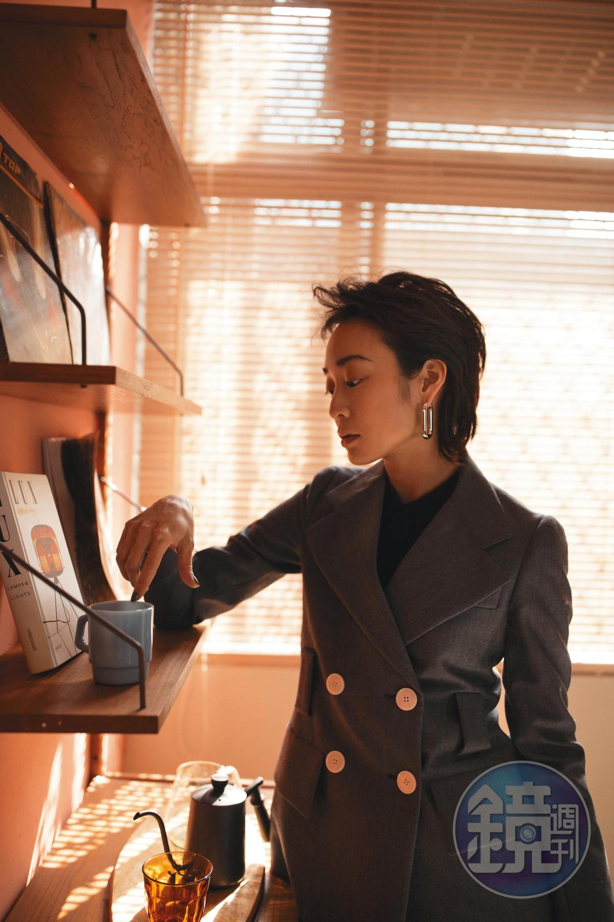 灰色雙排釦西裝外套 價格店洽 by PRADA；黑色襯衫 價格店洽 by PRADA；銀色單圈耳環 價格店洽 by FENDI。