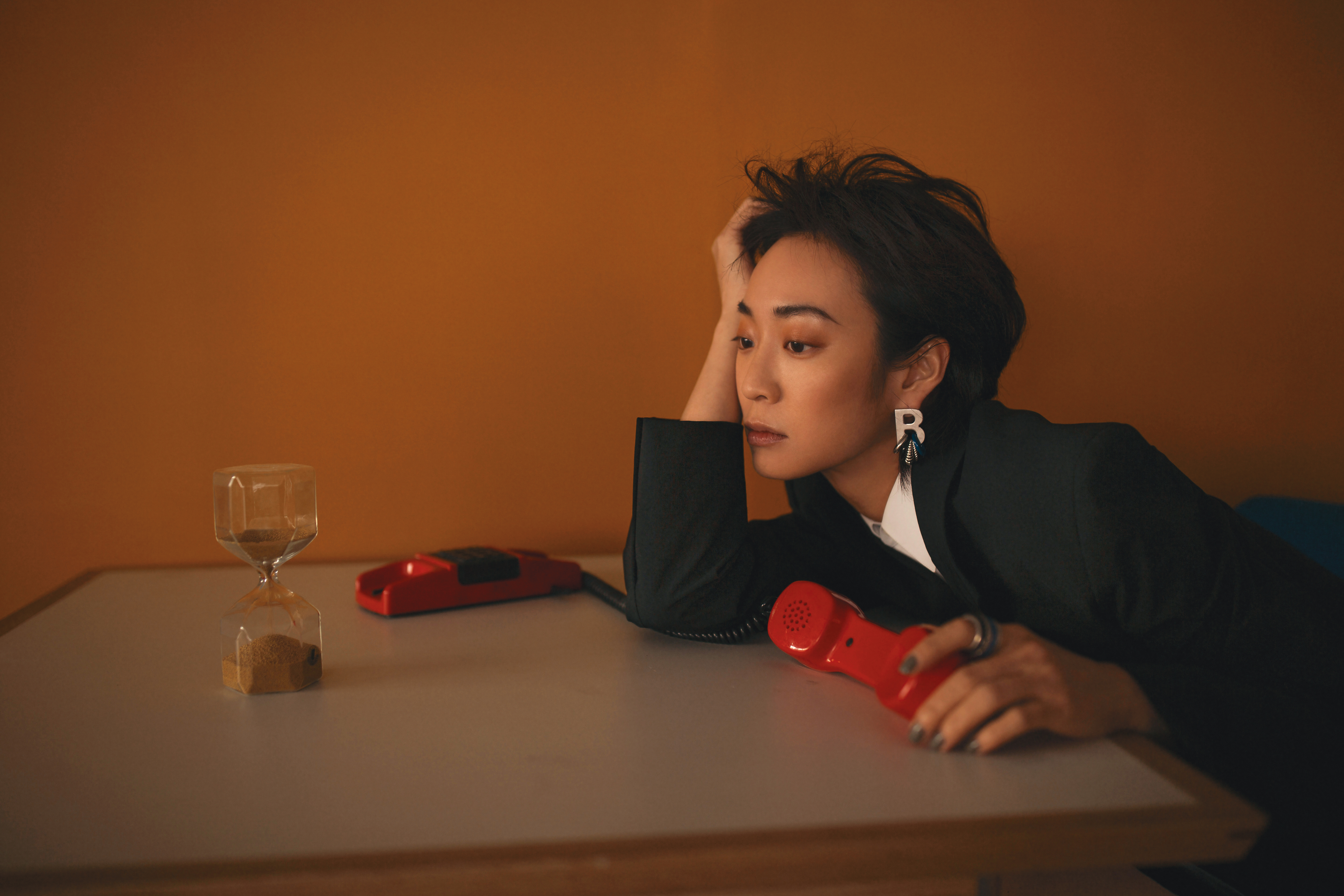 黑色西裝外套 NT$81,900 by BOTTEGA VENETA；白色襯衫 NT$17,500 by CELINE；字母多圈耳環 價格店洽 by BALENCIAGA；多圈戒指 NT$14,100 by BALENCIAGA。