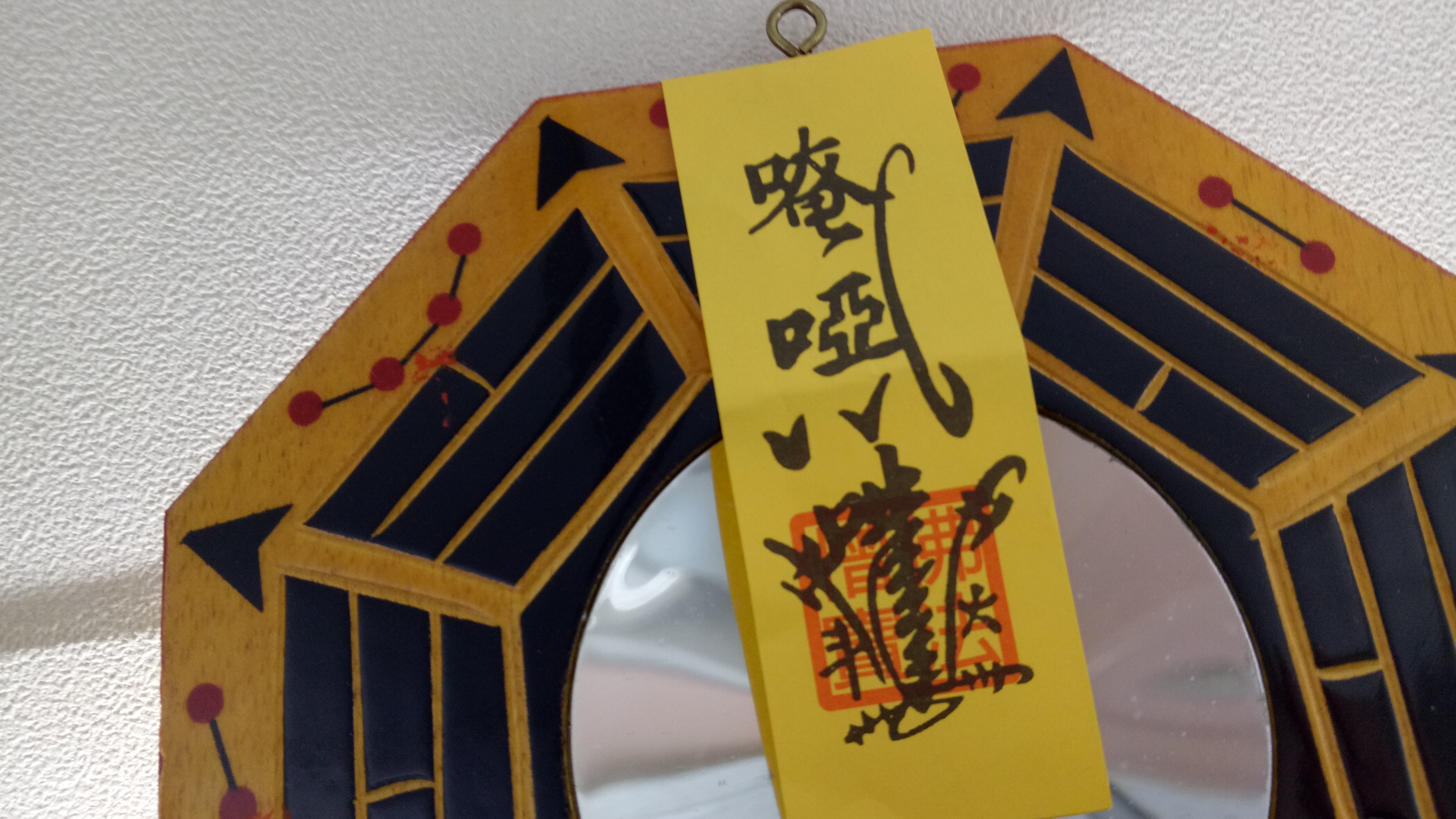 八卦鏡上的符咒印有「唵啞吽」「佛法僧寶」等字樣。