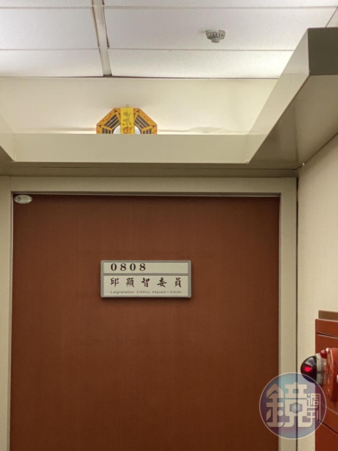時代力量立委邱顯智研究室門上懸掛一面貼了符咒的八卦鏡。