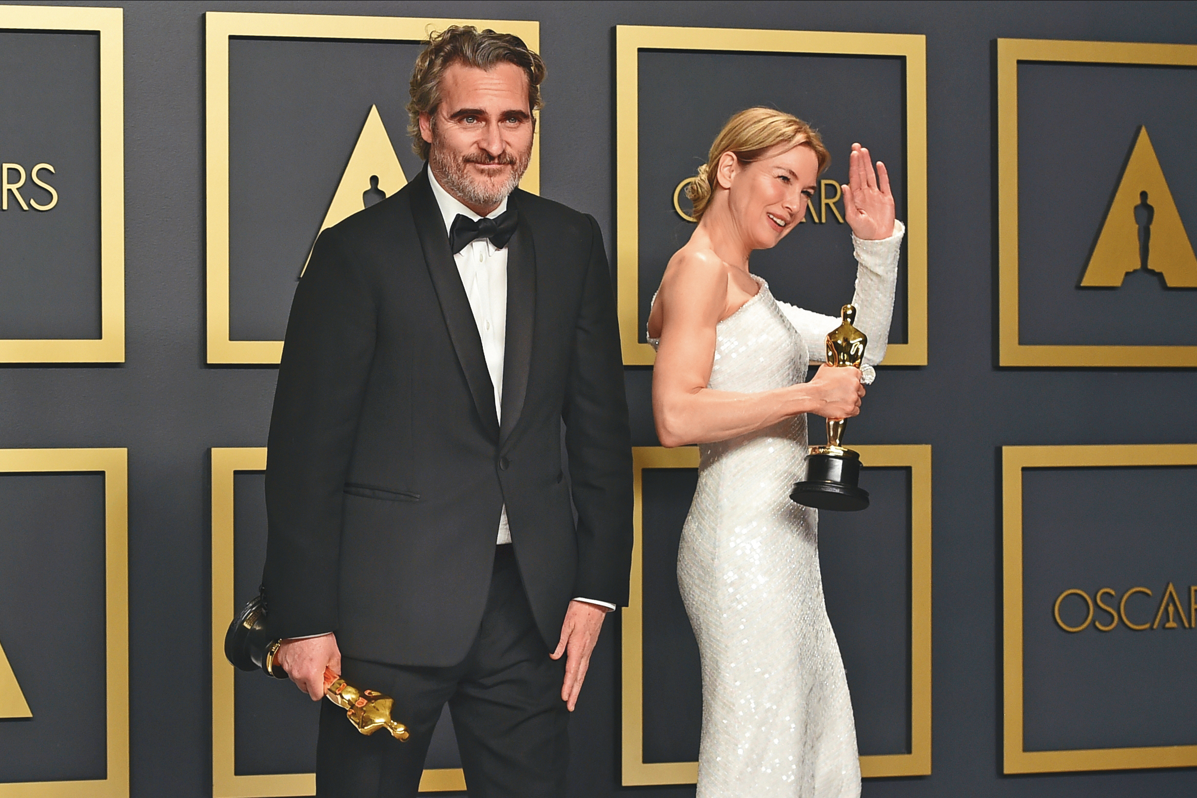 新出爐的奧斯卡影帝瓦昆菲尼克斯（左）與芮妮齊薇格，一個萌笑一個忙著與媒體打招呼，帝后合體的畫面好生動。（東方IC）