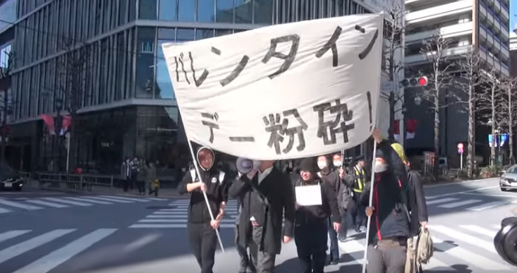 「革命性不受歡迎同盟」在東京澀谷街頭發起遊行，高喊「粉碎情人節」等口號。（翻攝自Youtube）