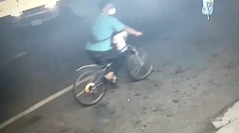 一名戴口罩歹徒，昨（12）日晚騎腳踏車到太平一家彩券行，亮槍行搶現金。（翻攝畫面）