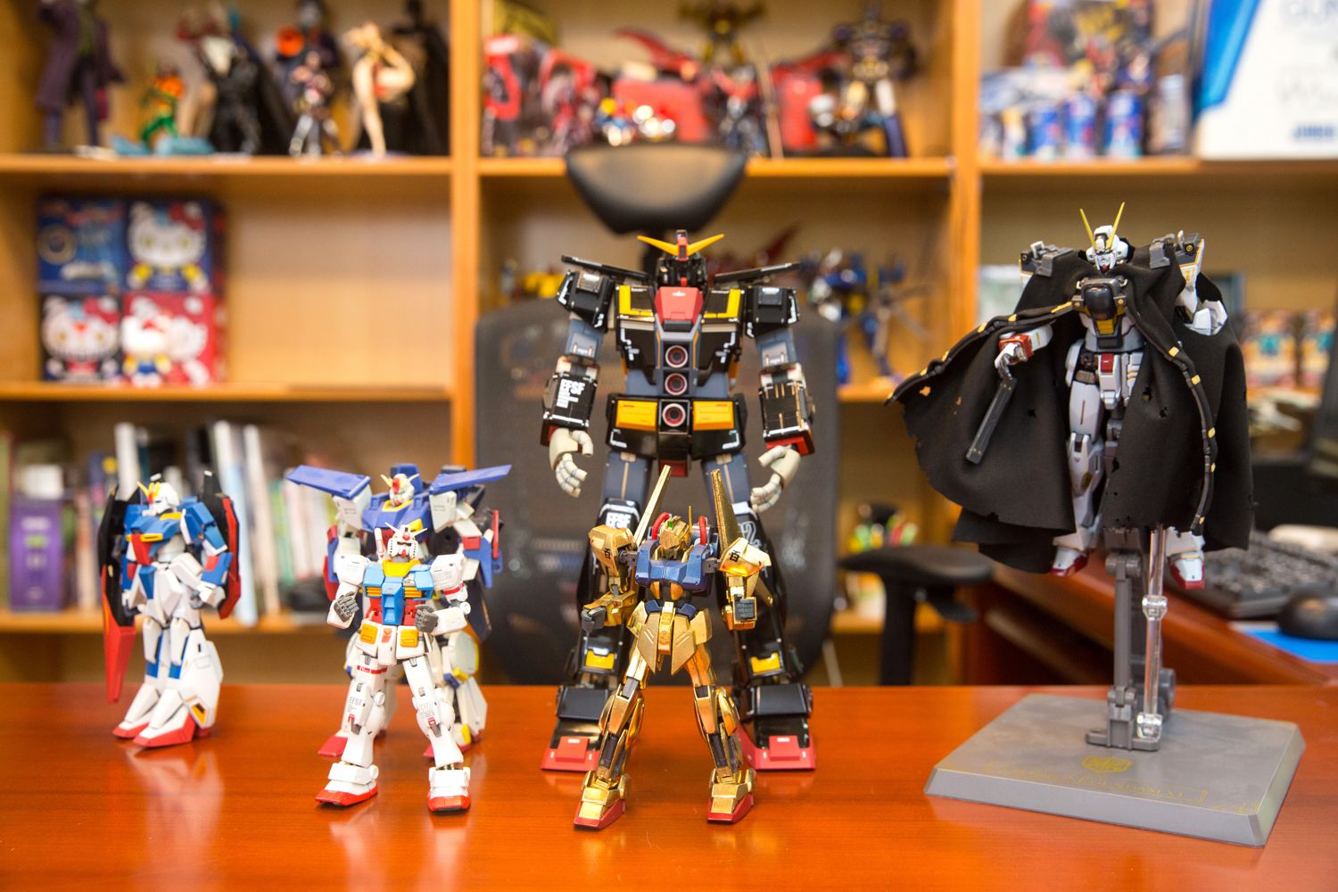 鄭運鵬從紙箱中隨手拿了幾台鋼彈玩具，擺放在桌上供攝影拍攝。在購入解體匠機之前，中間的精神感應鋼彈是鄭運鵬得意的收藏。