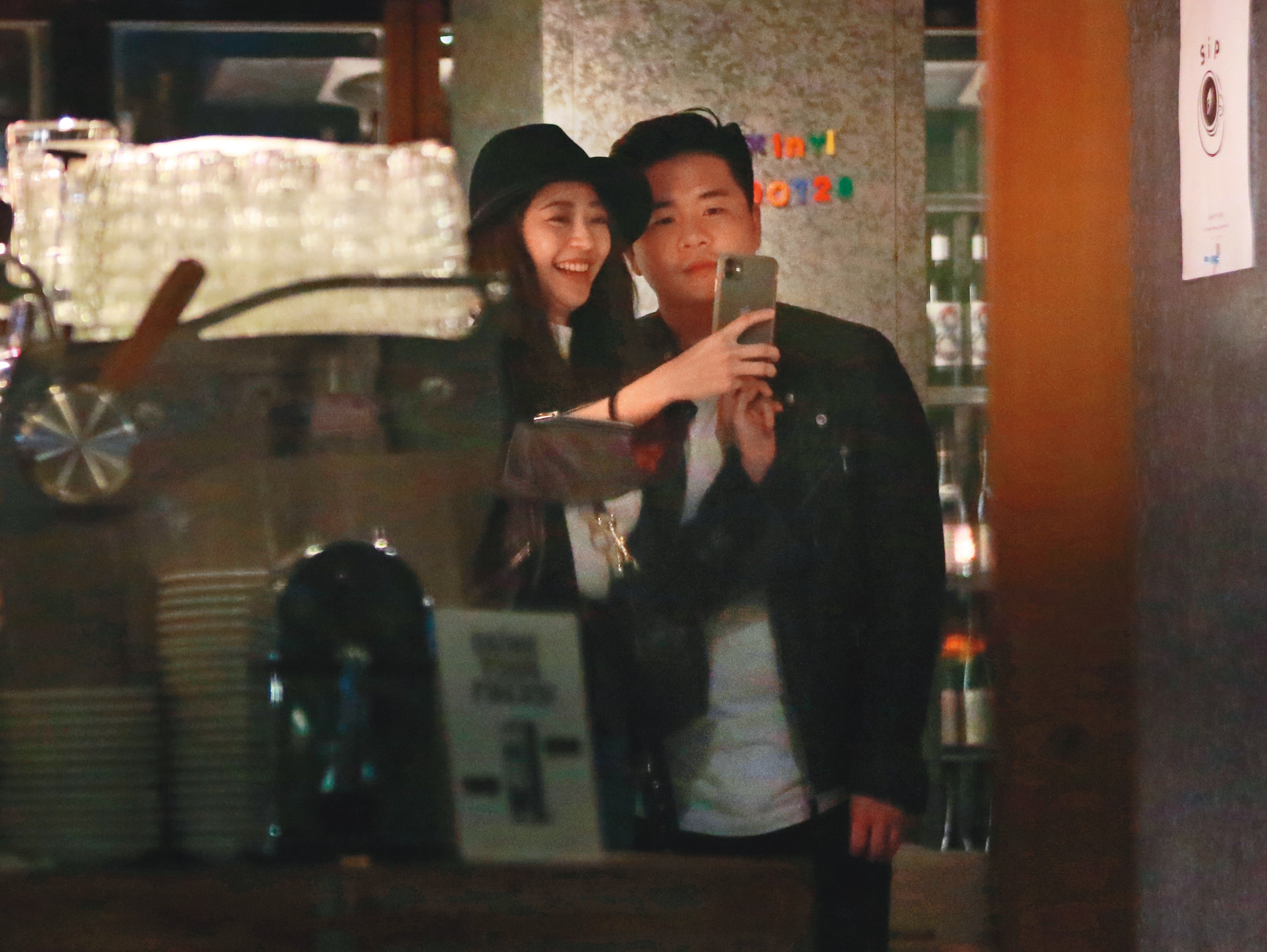  2／12 22：30，兩人吃飽喝足後走出餐廳，陳育涵滿臉甜蜜笑容在門口和皮衣男玩自拍。