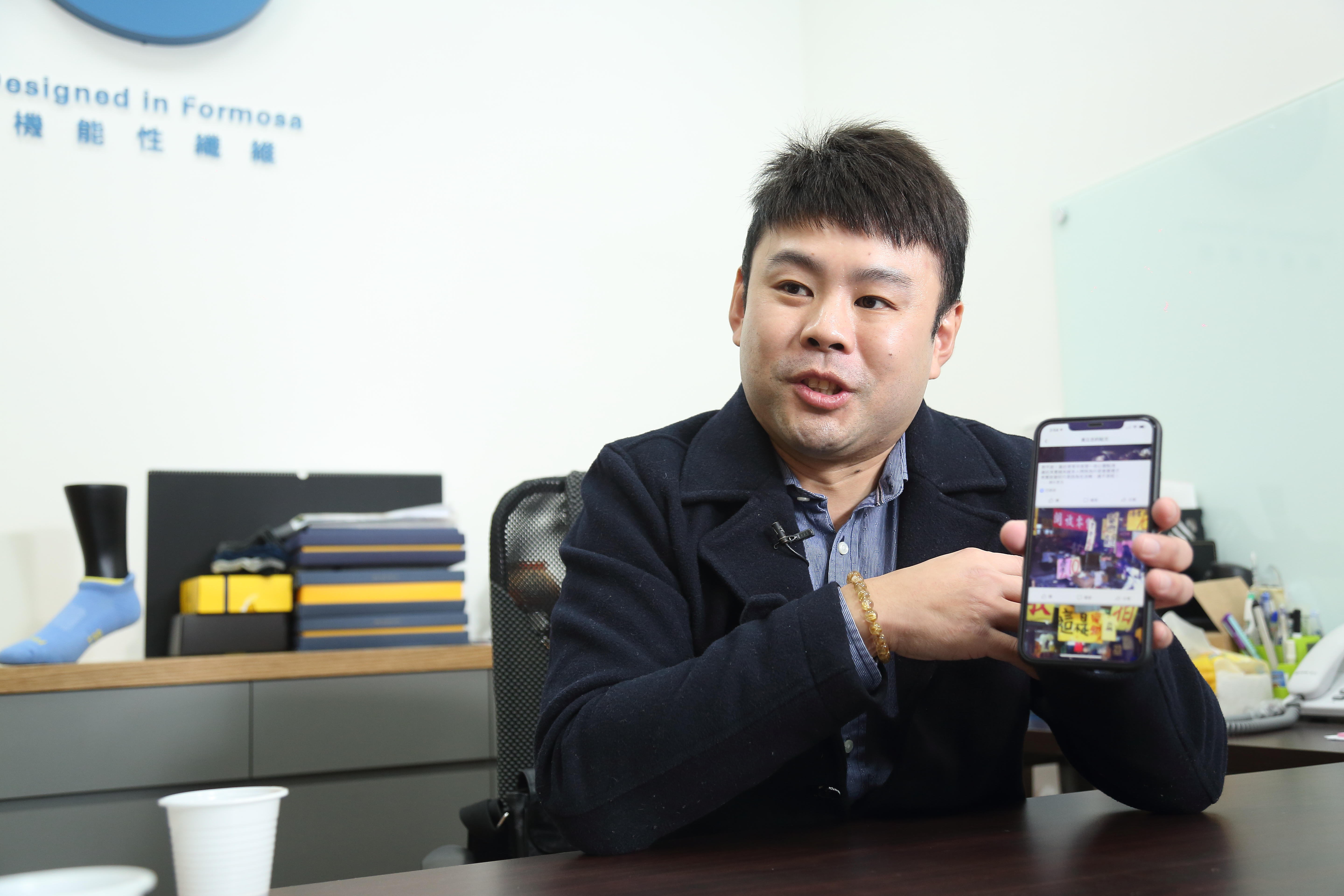 黃立忠打開手機給我們看當年擺攤照片，他從姊夫那兒學來做生意模式，在菜市場賣襪賣得嚇嚇叫。