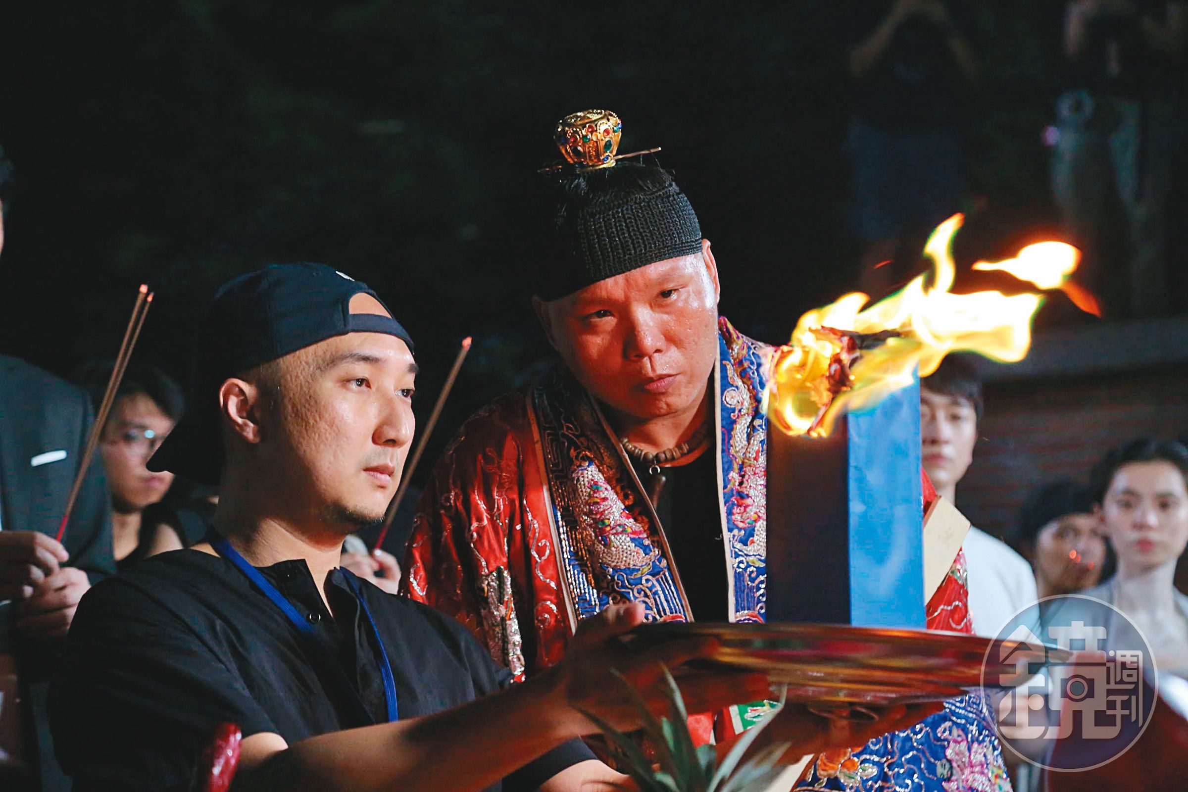 經驗豐富的宗教顧問龍哥（前右）在拍片現場把關，讓導演奚岳隆（前左）與劇組平安拍攝。（傳影互動提供）