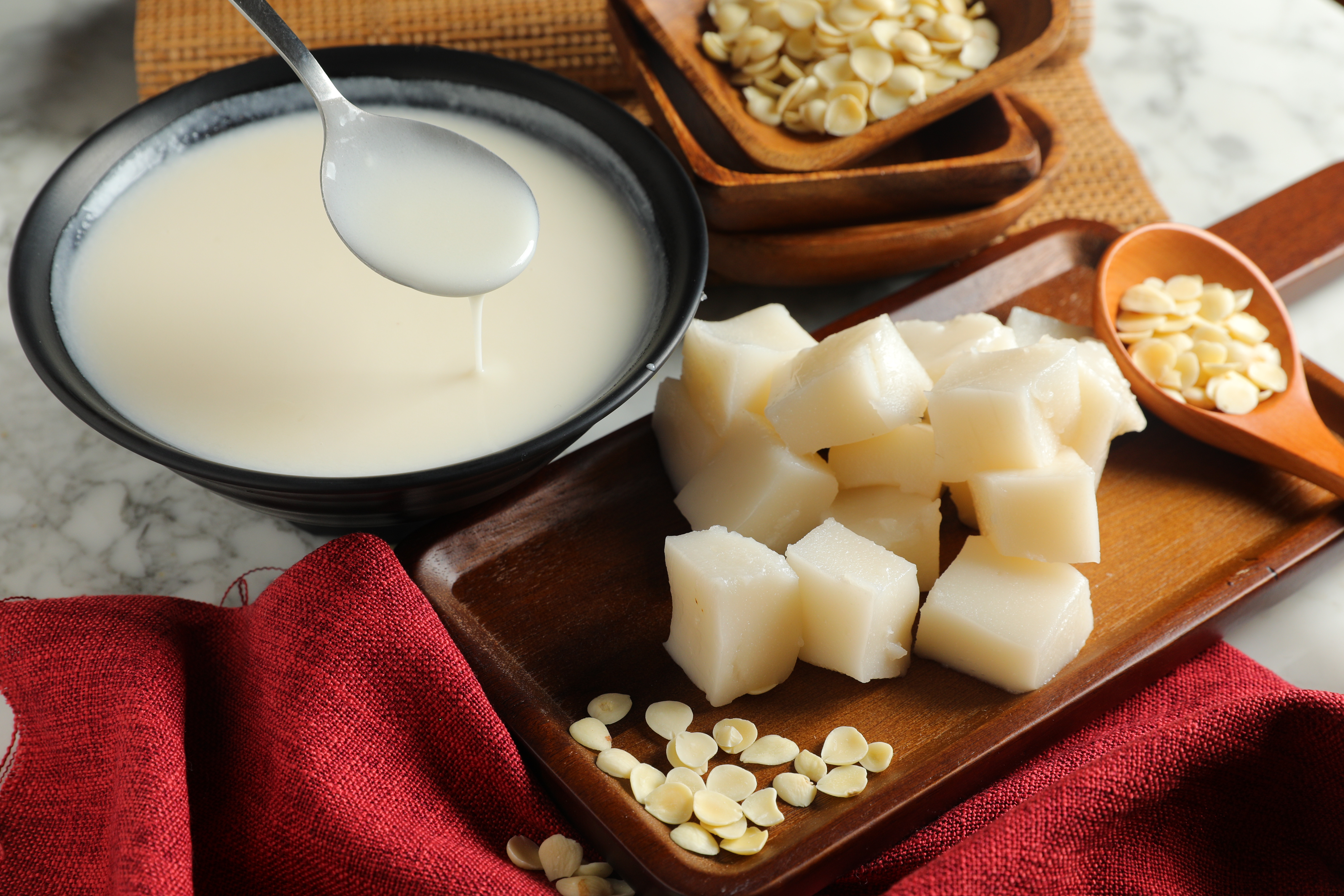 「杏仁奶」（左，65元／碗，送1種配料、80元／碗，可任選3種配料）「杏仁粿」（附贈配料選項）是靈魂伴侶，享軟Q、濃滑雙口感。