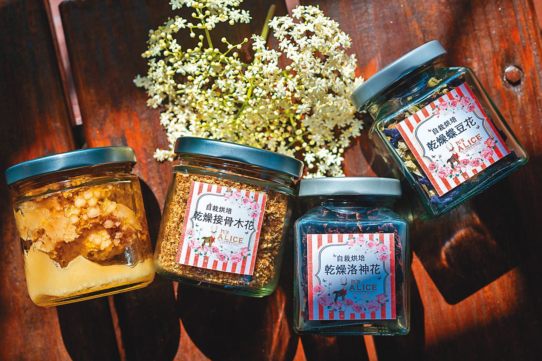 自產「蜂巢蜜」（左起）(500元／250克）、「乾燥接骨木花」（430元／罐）、「乾燥洛神花」（120元／罐）、「乾燥蝶豆花」（200元／罐）。