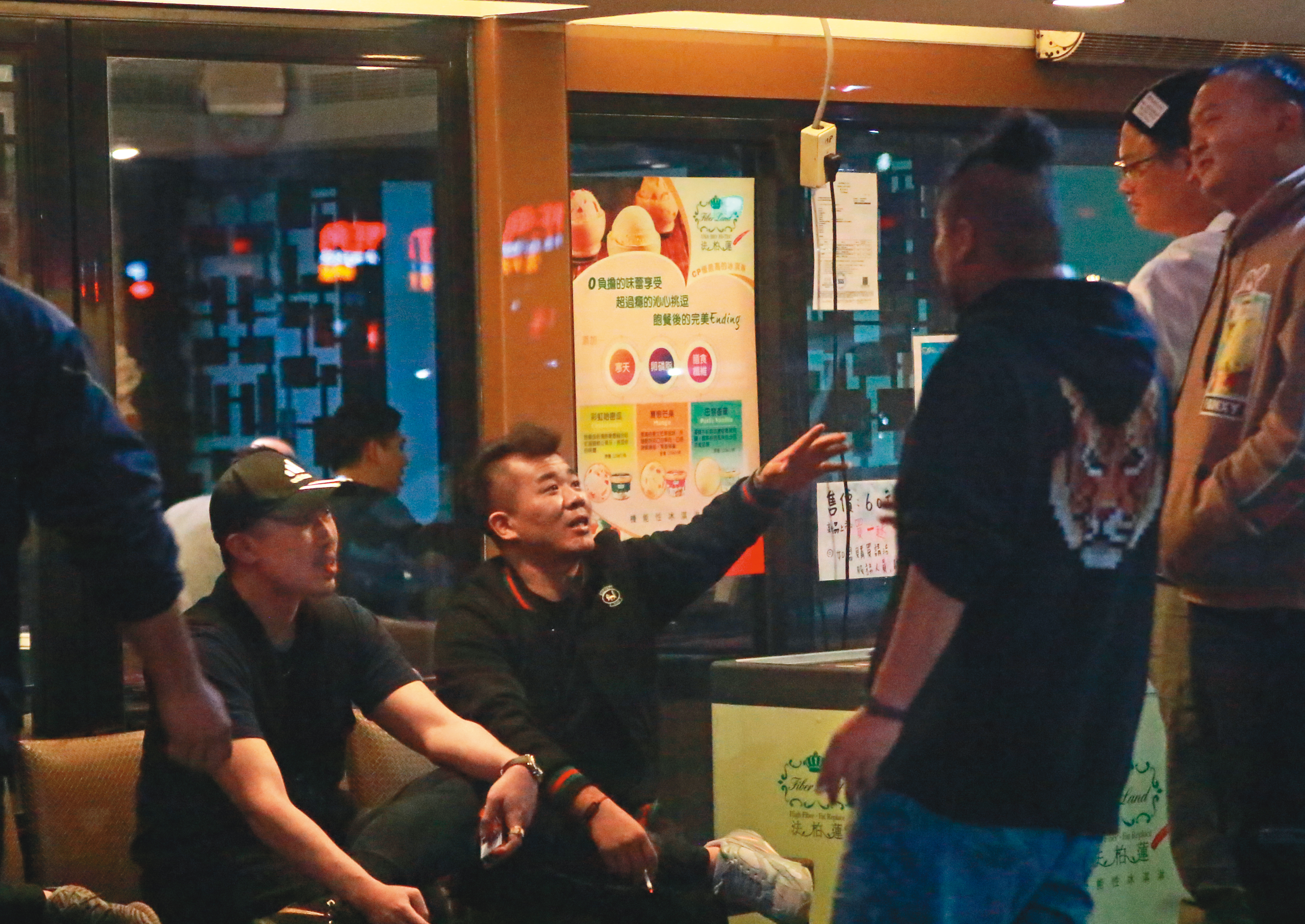 2/24 00:48 門口哈菸哈不夠，游否希（右三）等4人又坐下繼續哈。