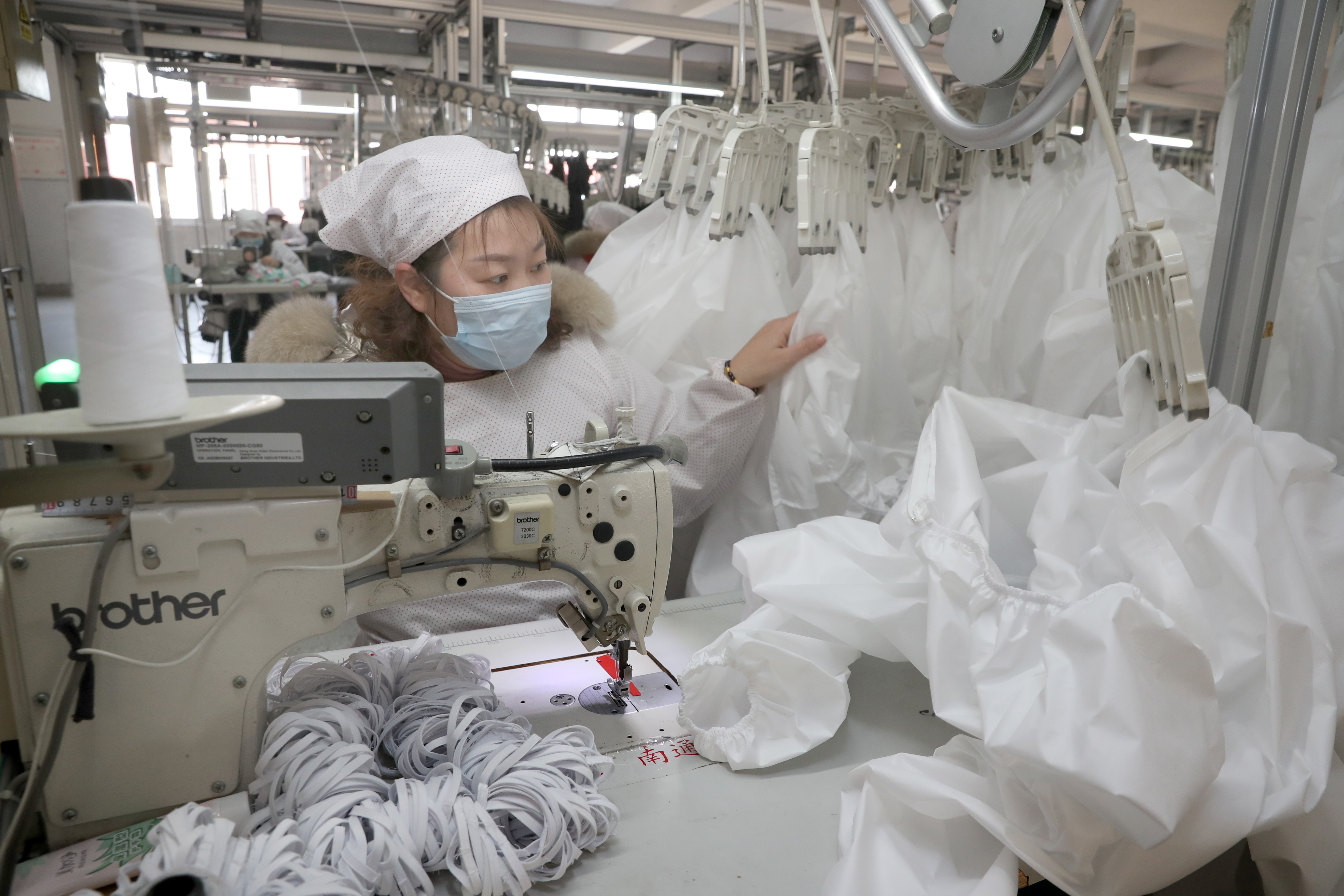 圖為江蘇一工廠趕製防疫服送往武漢、宜昌等地。（東方IC）