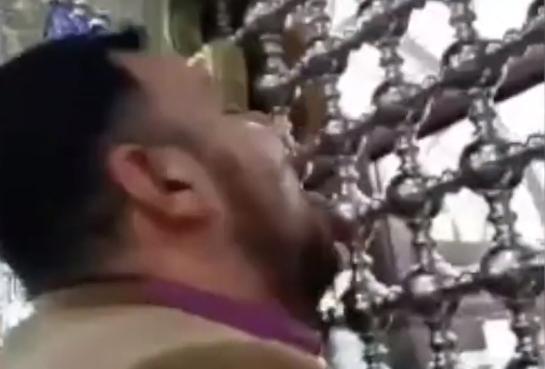 伊朗男子狂舔神殿的門秀虔誠。（翻攝自推特）