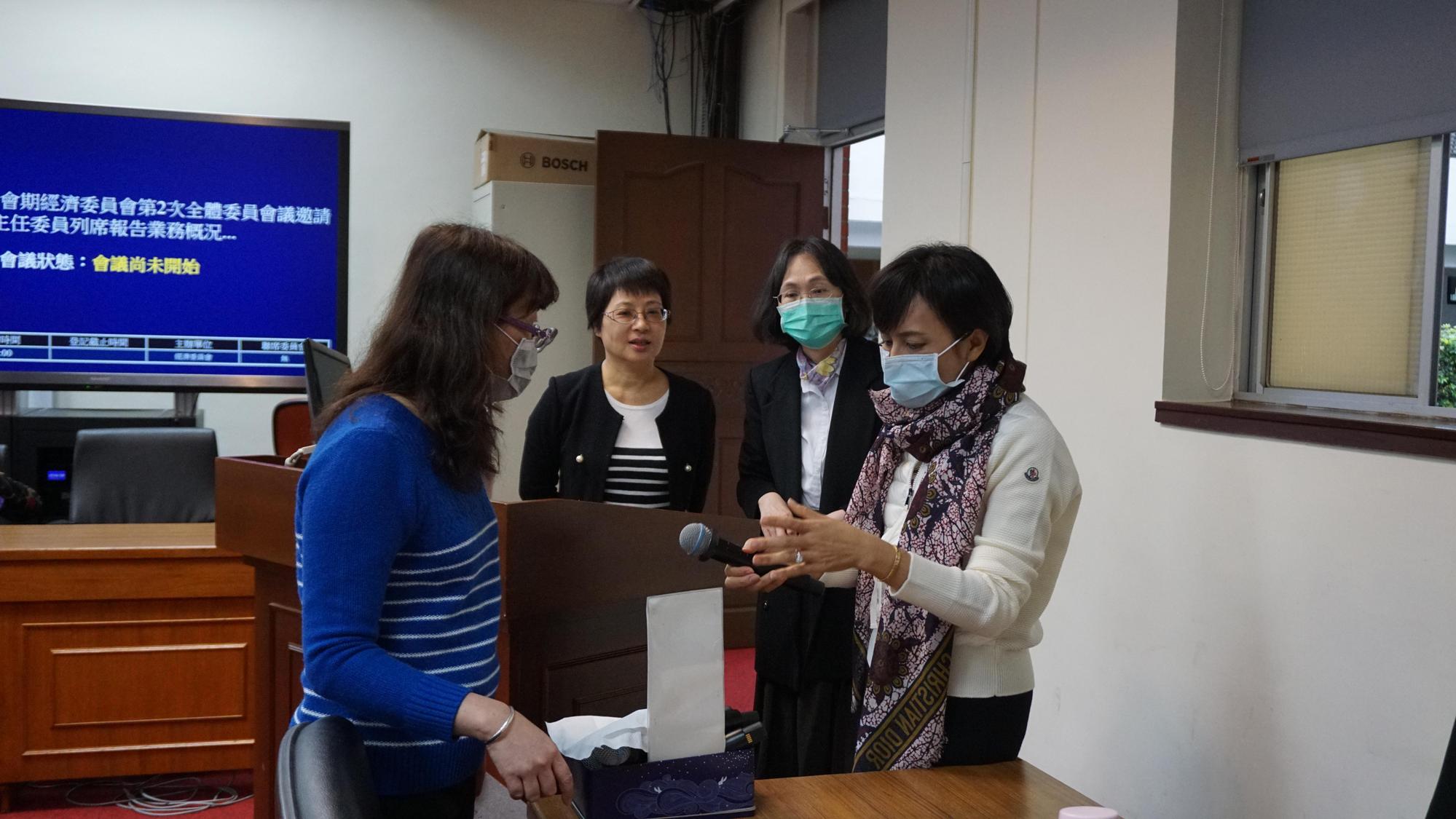 經濟委員會召委邱議瑩和議事人員確認無線麥克風消毒狀況。（邱議瑩辦公室提供）