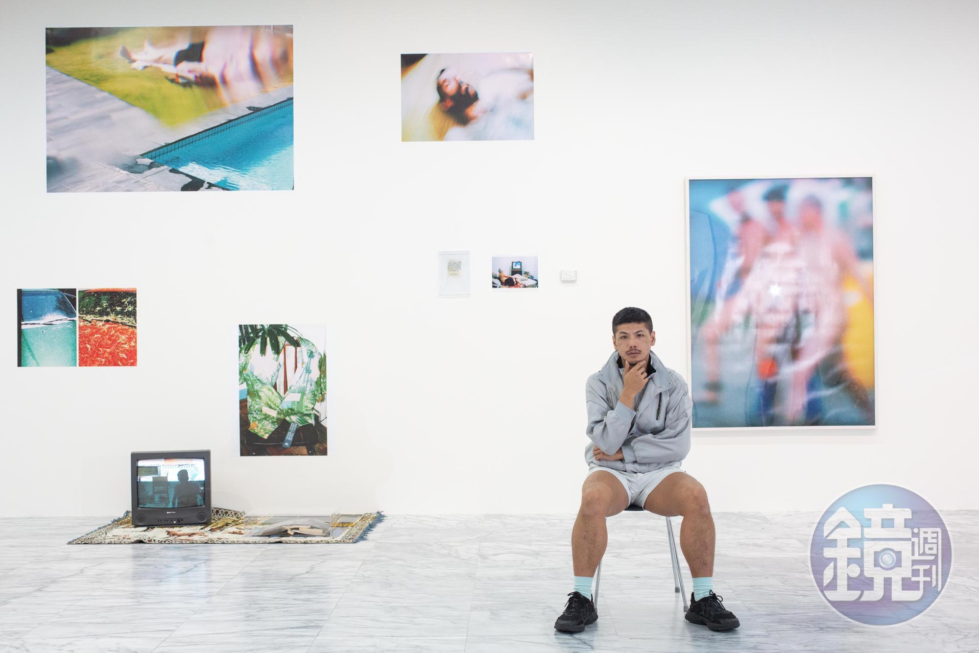 楊登棋在美術館展出台北美術獎首獎作品,背後那面牆上照片是他所拍,繽紛多彩:「照片是我的日記,我很想跟爸爸分享我的生活,但他始終難以啟齒,其實沒辦法真的對話。」