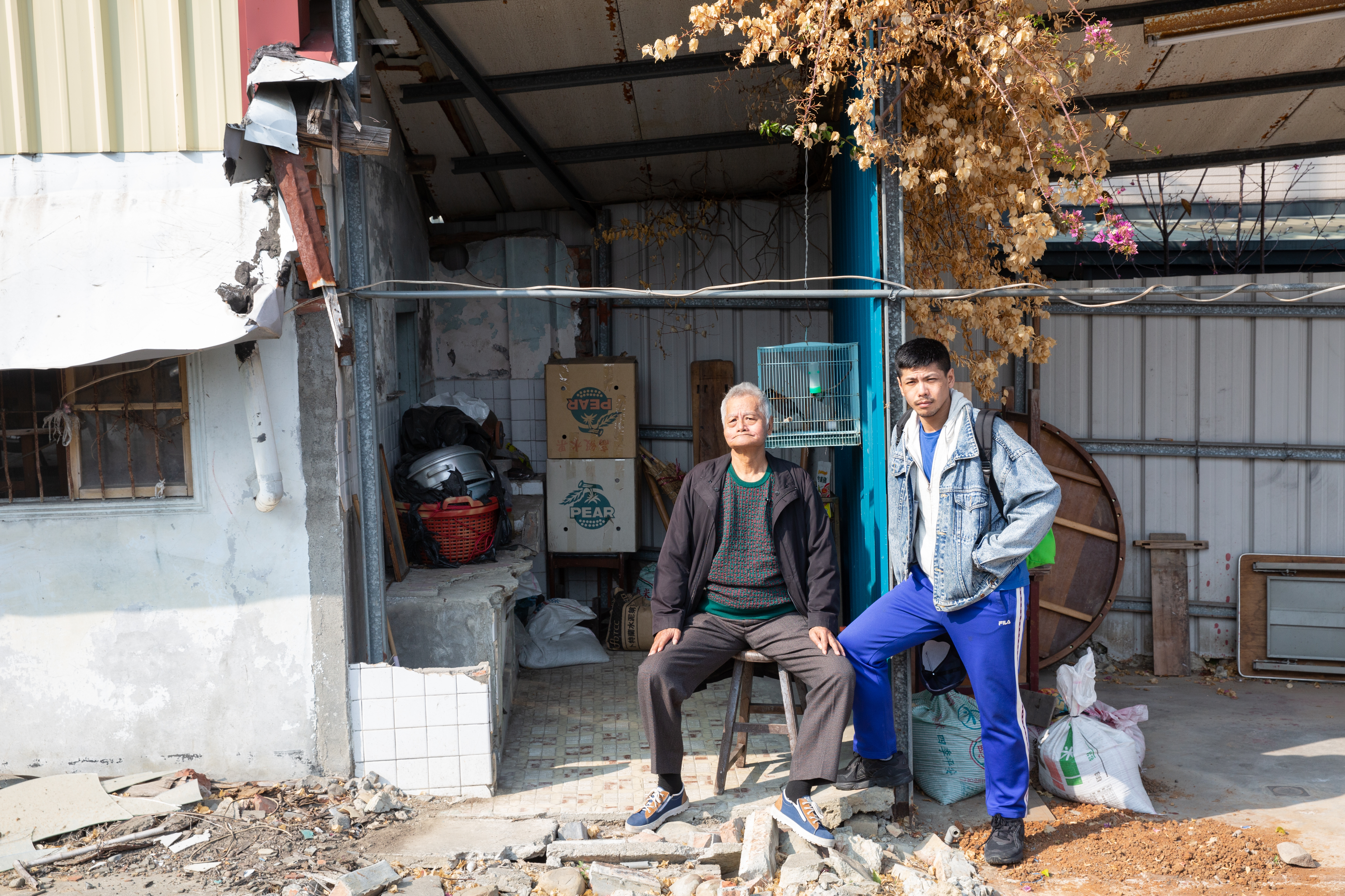 楊登棋（右）和父親楊嘉銘（左）的合照。背景是父親老家，因家族土地被政府徵收開路，老屋拆了準備重建。