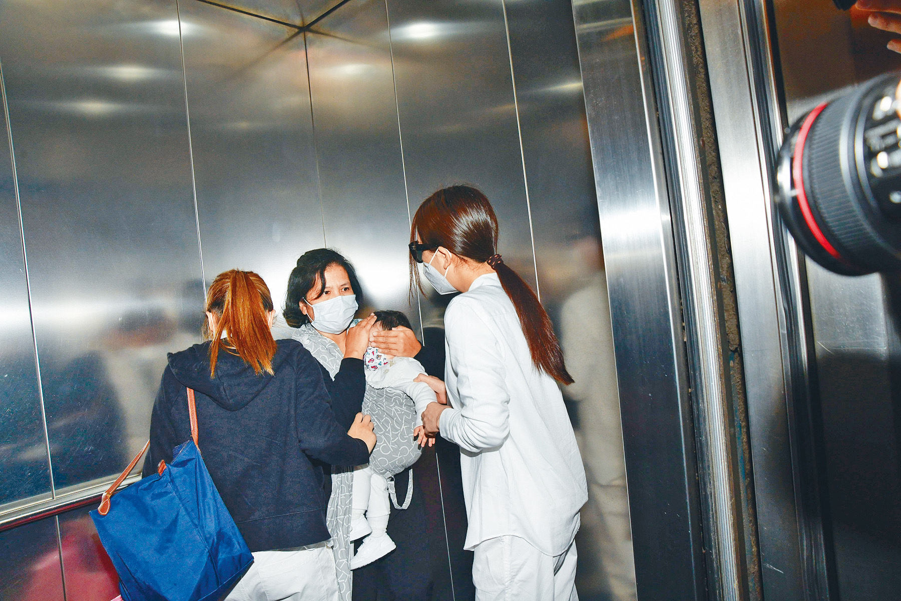 為免兩個女兒容貌被攝入鏡頭,傭人全程用手遮住她們的臉。(東方IC)