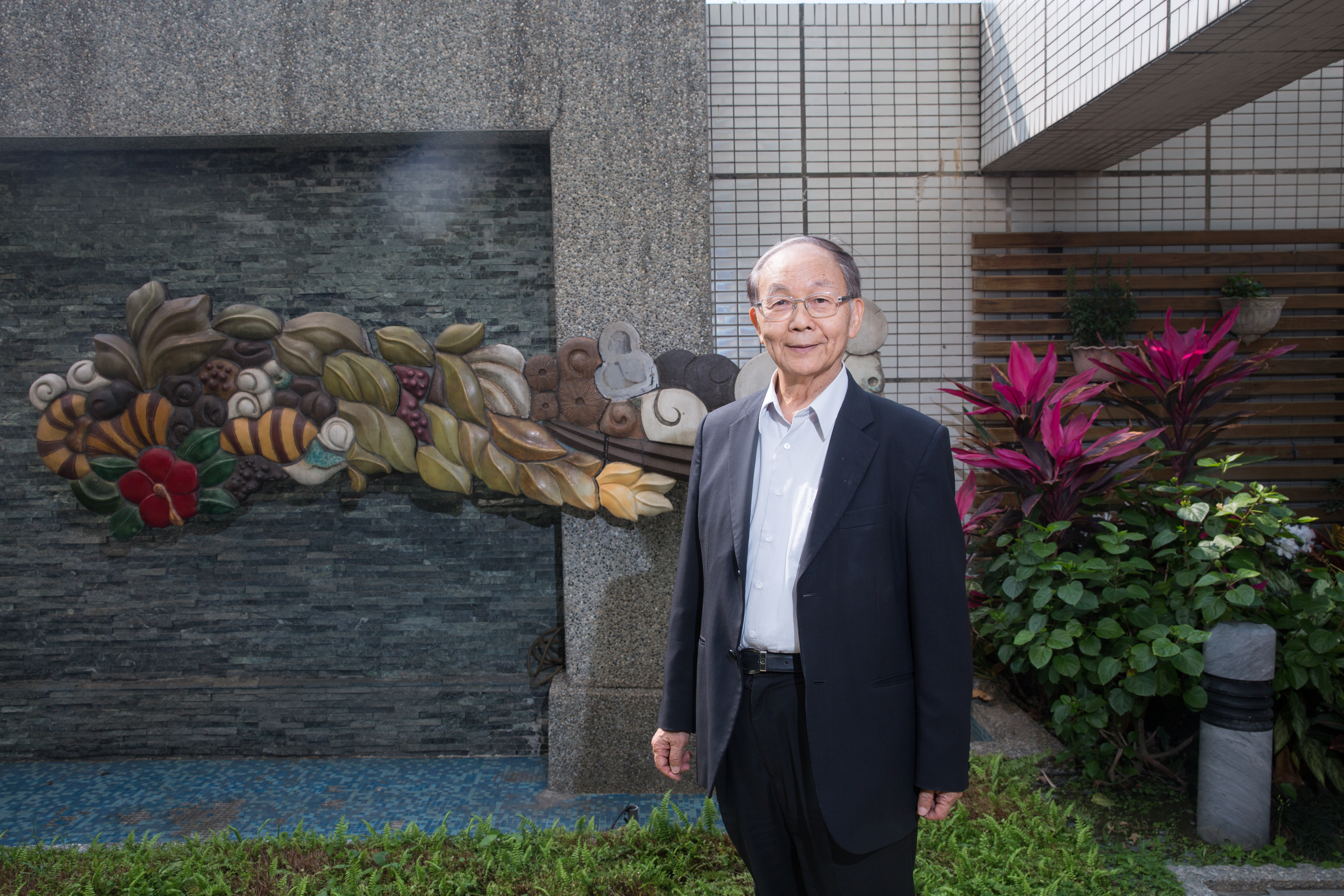 郭聰田鼓勵員工多參與藝術活動，他身後的大型陶壁作品出自藝術家七子之手。