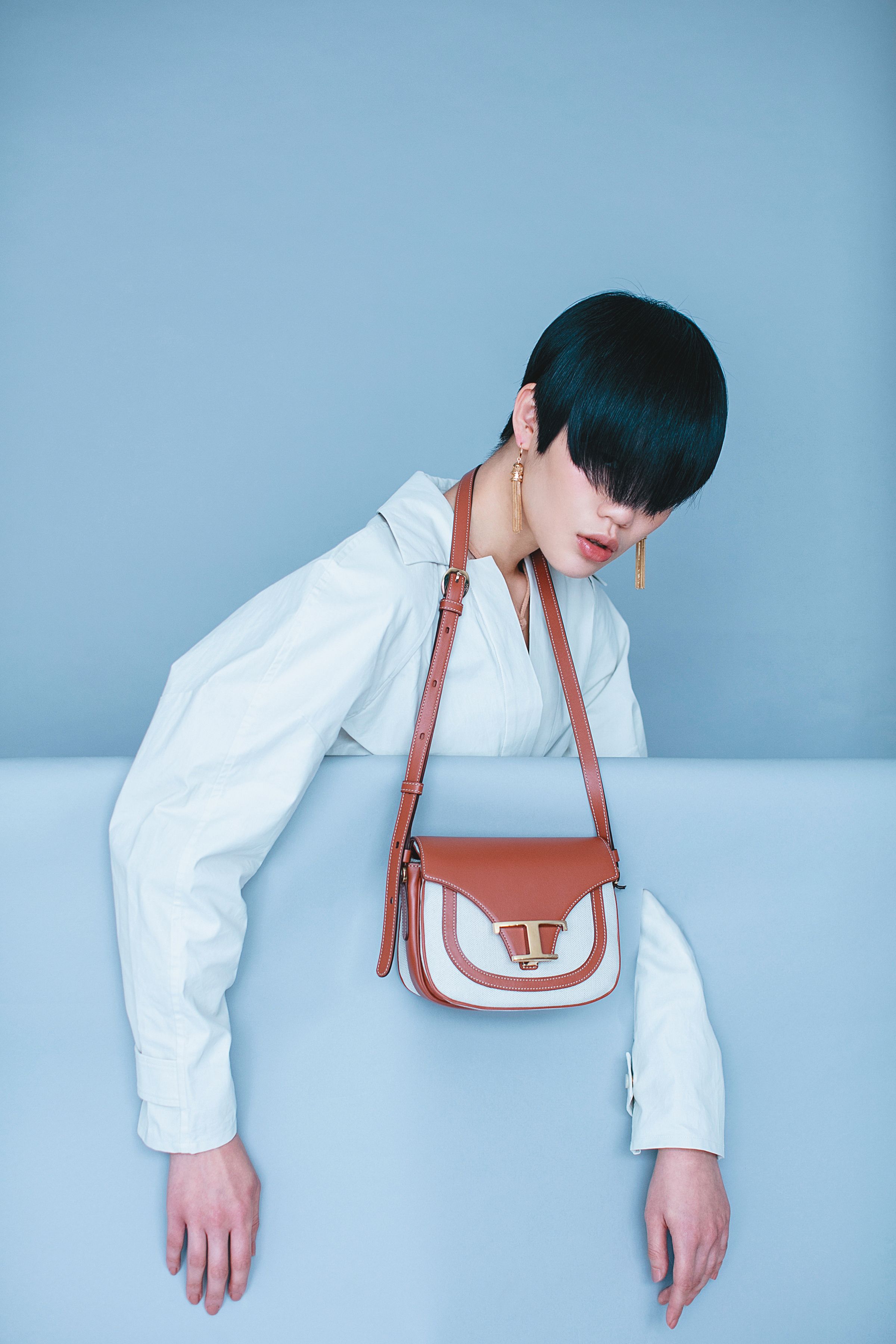 雪白色襯衫洋裝 NT$63,900 by BOTTEGA VENETA／裸色混喀什米爾羊毛連身背心 NT$45,900 by BOTTEGA VENETA／Timeless帆布皮革拼接馬鞍包 NT$62,700 by TOD'S／ aillons Triomphe 金屬黃銅流蘇造型耳環 NT$28,000 by CELINE