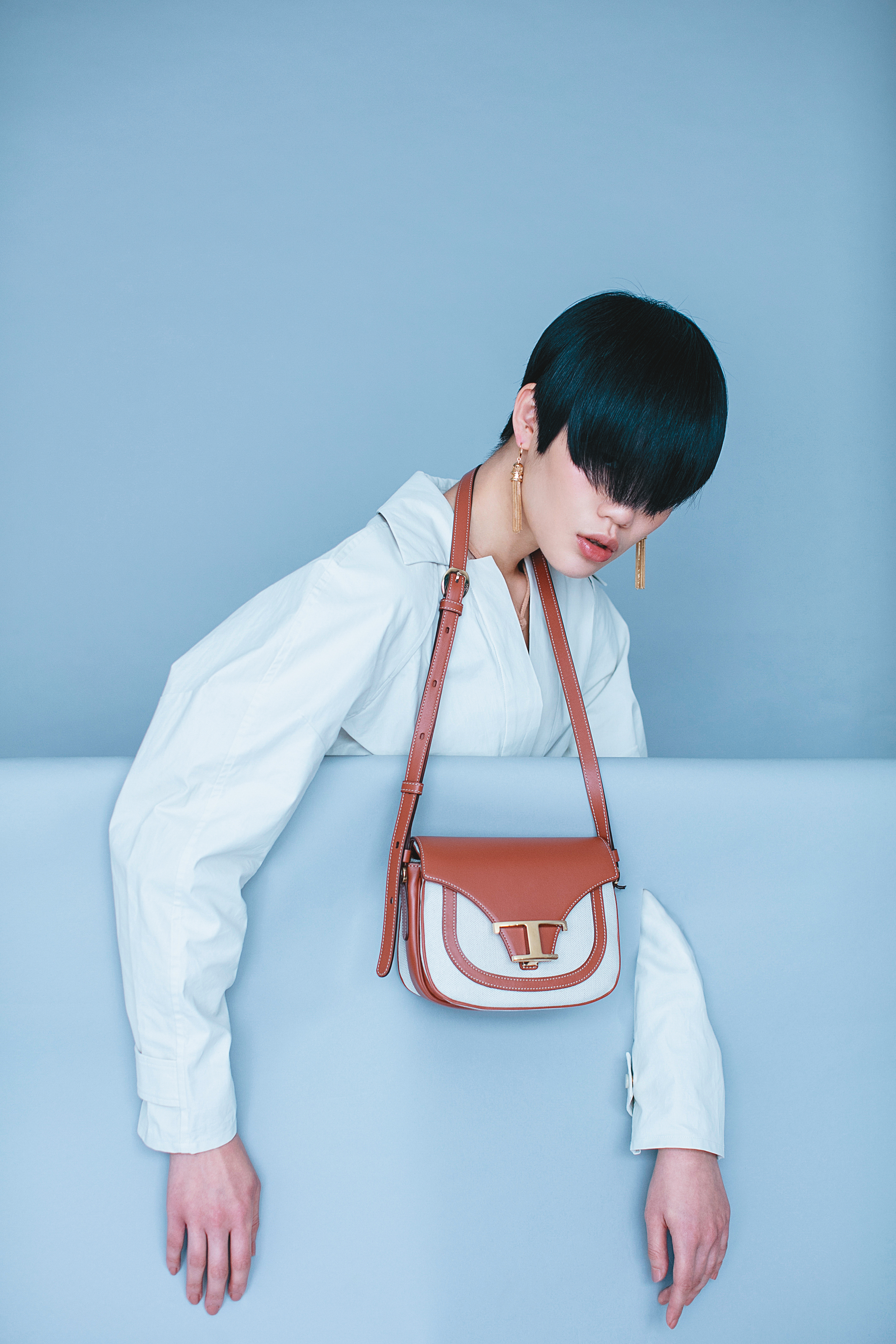 雪白色襯衫洋裝 NT$63,900 by BOTTEGA VENETA／裸色混喀什米爾羊毛連身背心 NT$45,900 by BOTTEGA VENETA／Timeless帆布皮革拼接馬鞍包 NT$62,700 by TOD'S／ aillons Triomphe 金屬黃銅流蘇造型耳環 NT$28,000 by CELINE
