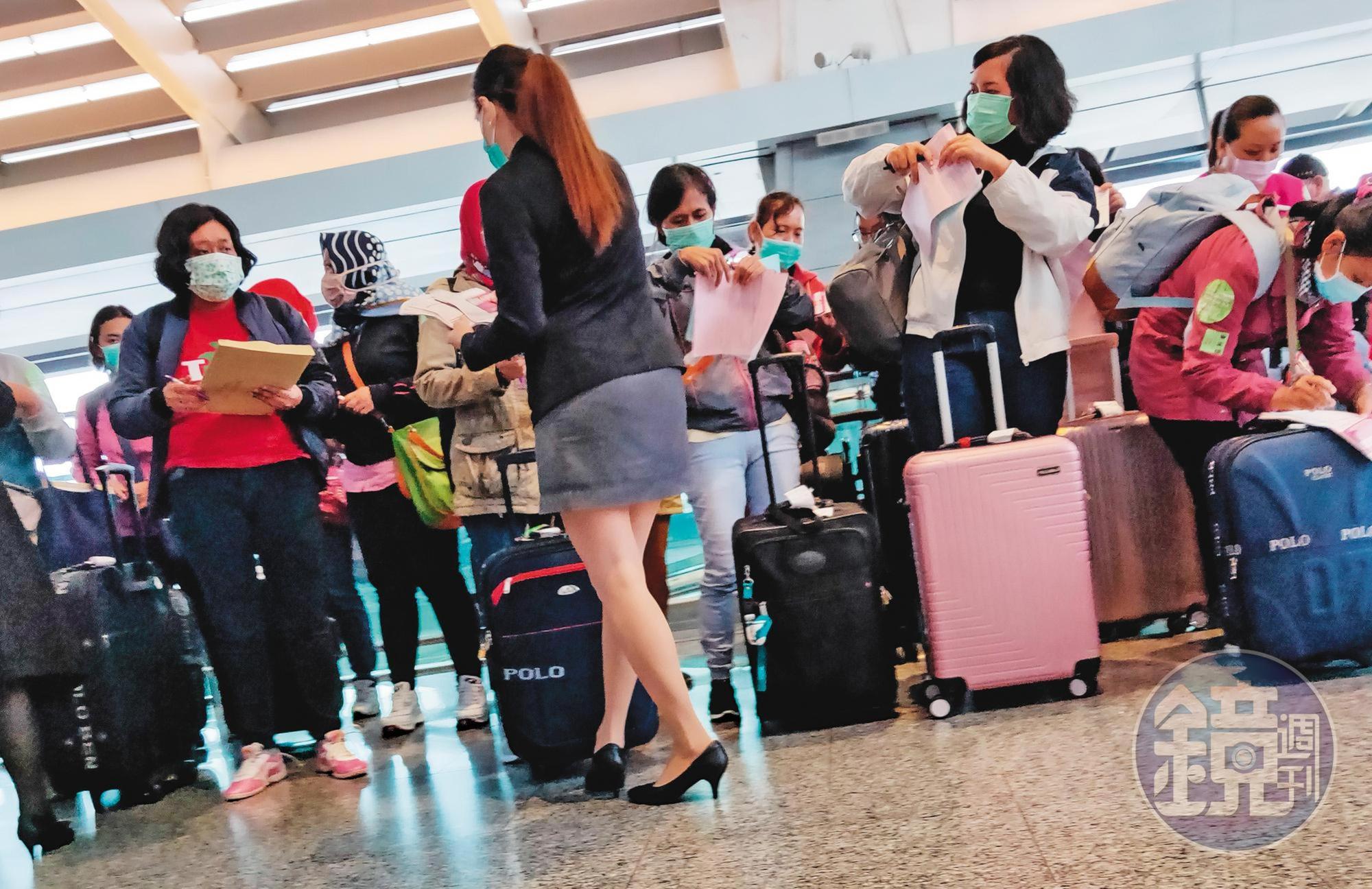 本刊直擊，身穿套裝的預付卡代理商發放預付卡申請單給每個移工填寫。