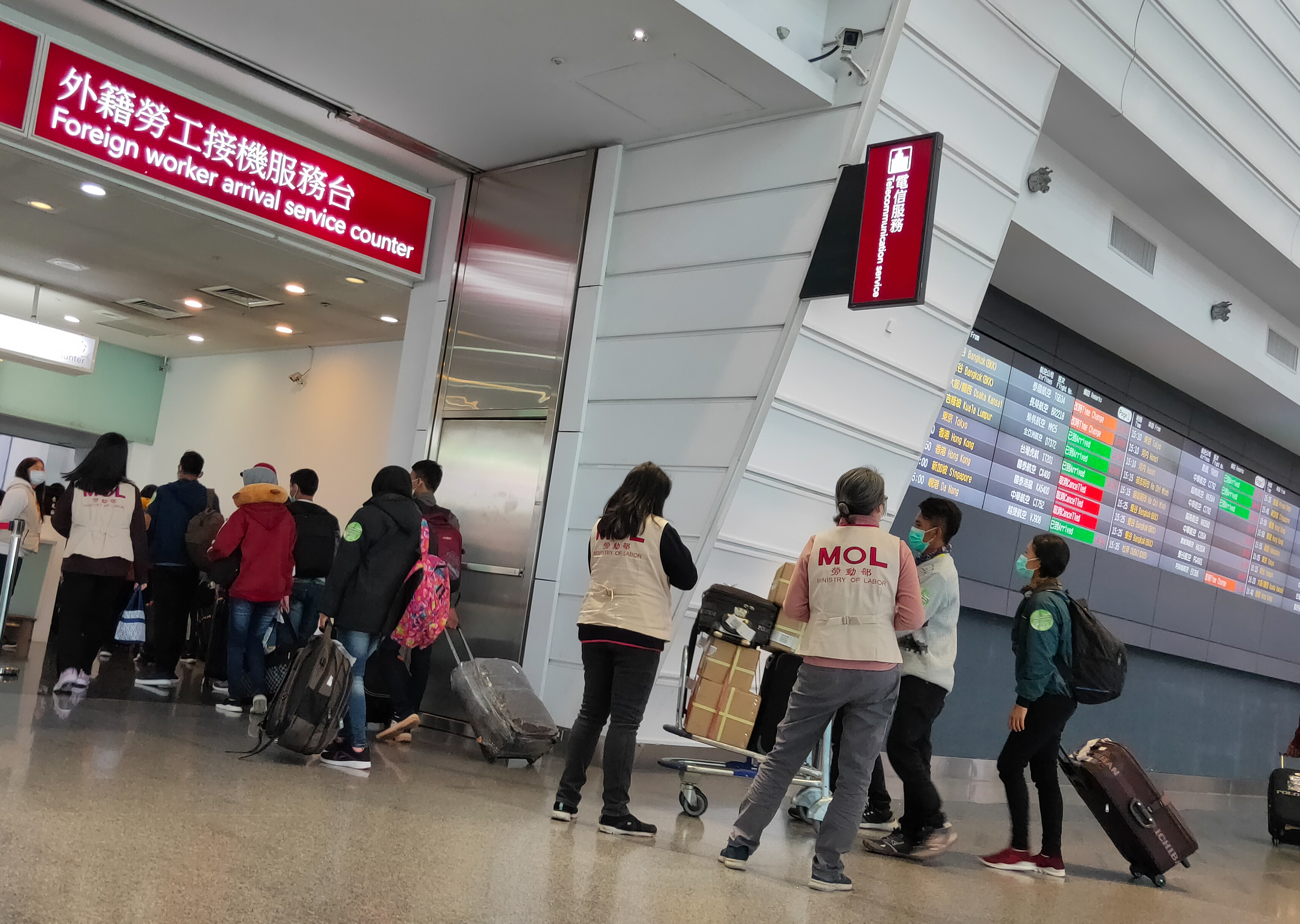 本刊直擊移工抵台後，身穿寫有「MOL」背心的勞動部人員將他們帶到外籍勞工接機服務台，進行講習宣導。