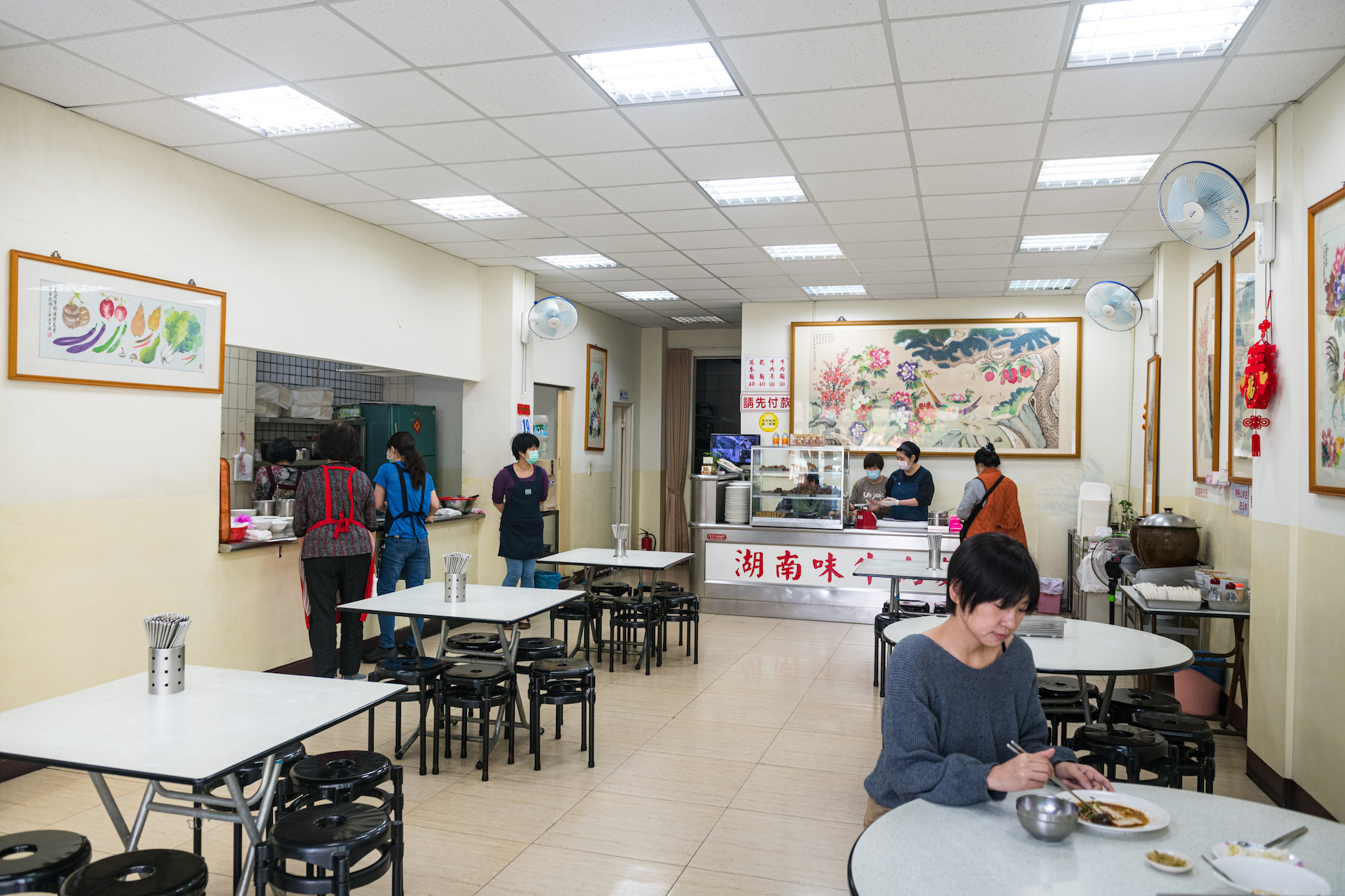 「湖南味」店面窗明几淨，牆上的掛畫皆出自創始老闆汪月濤之筆。