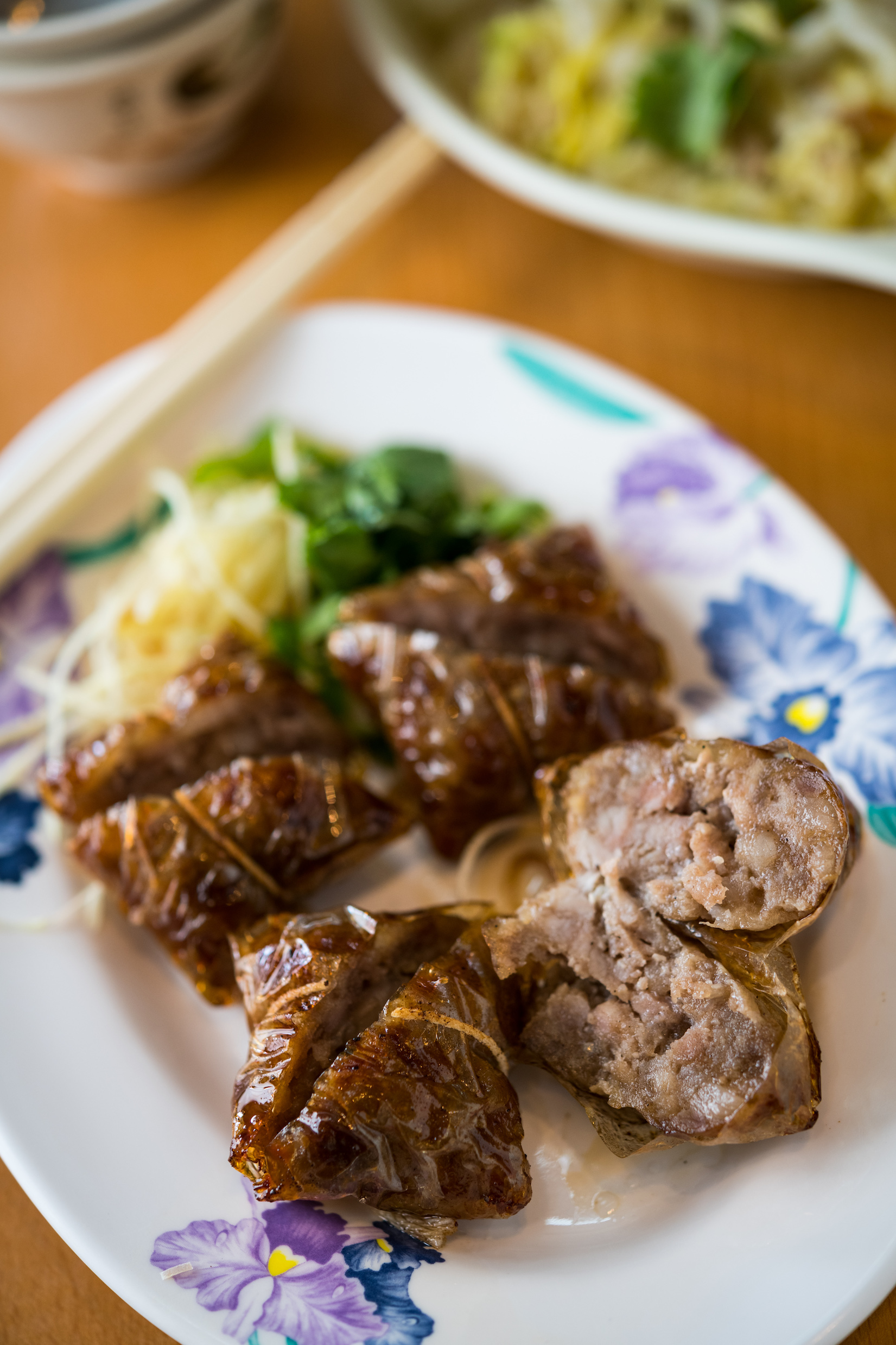 米紙包覆酥炸的「玻璃排骨」是自創手路菜,有南部藥膳香腸的風味。(100元/份)