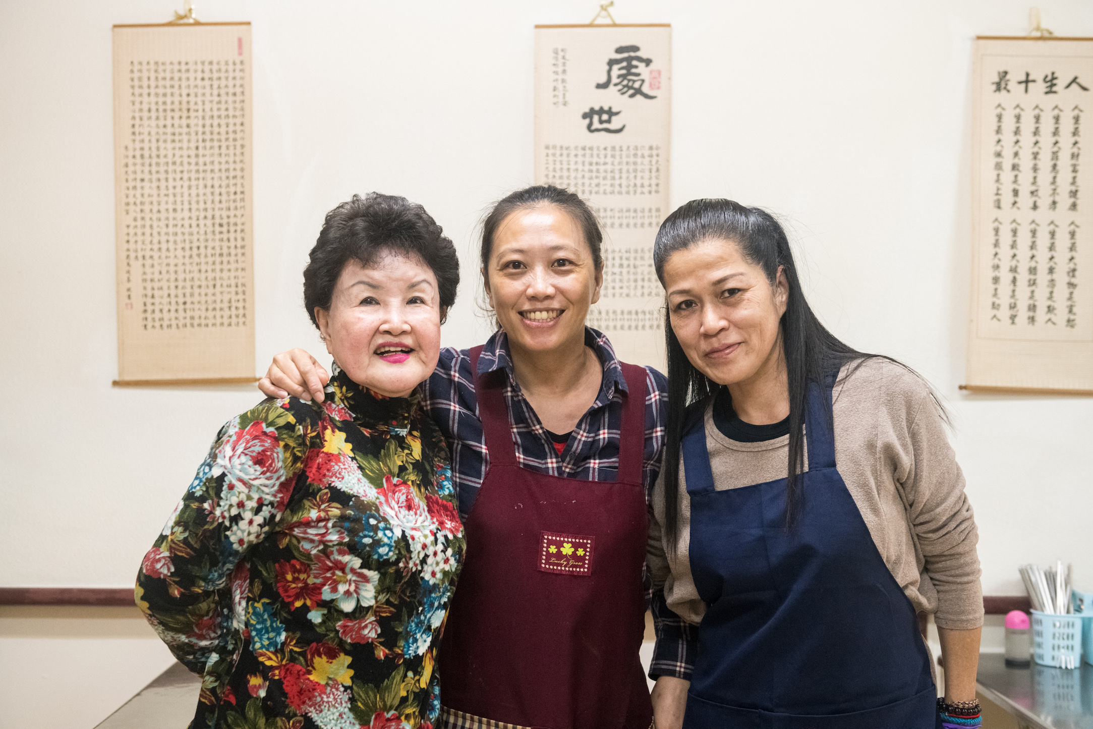 第三代老闆娘胡燕玲（中）與製作麻辣香腸的阿姨江玉珍（左）及店裡幫忙的員工，感情和睦如一家人。