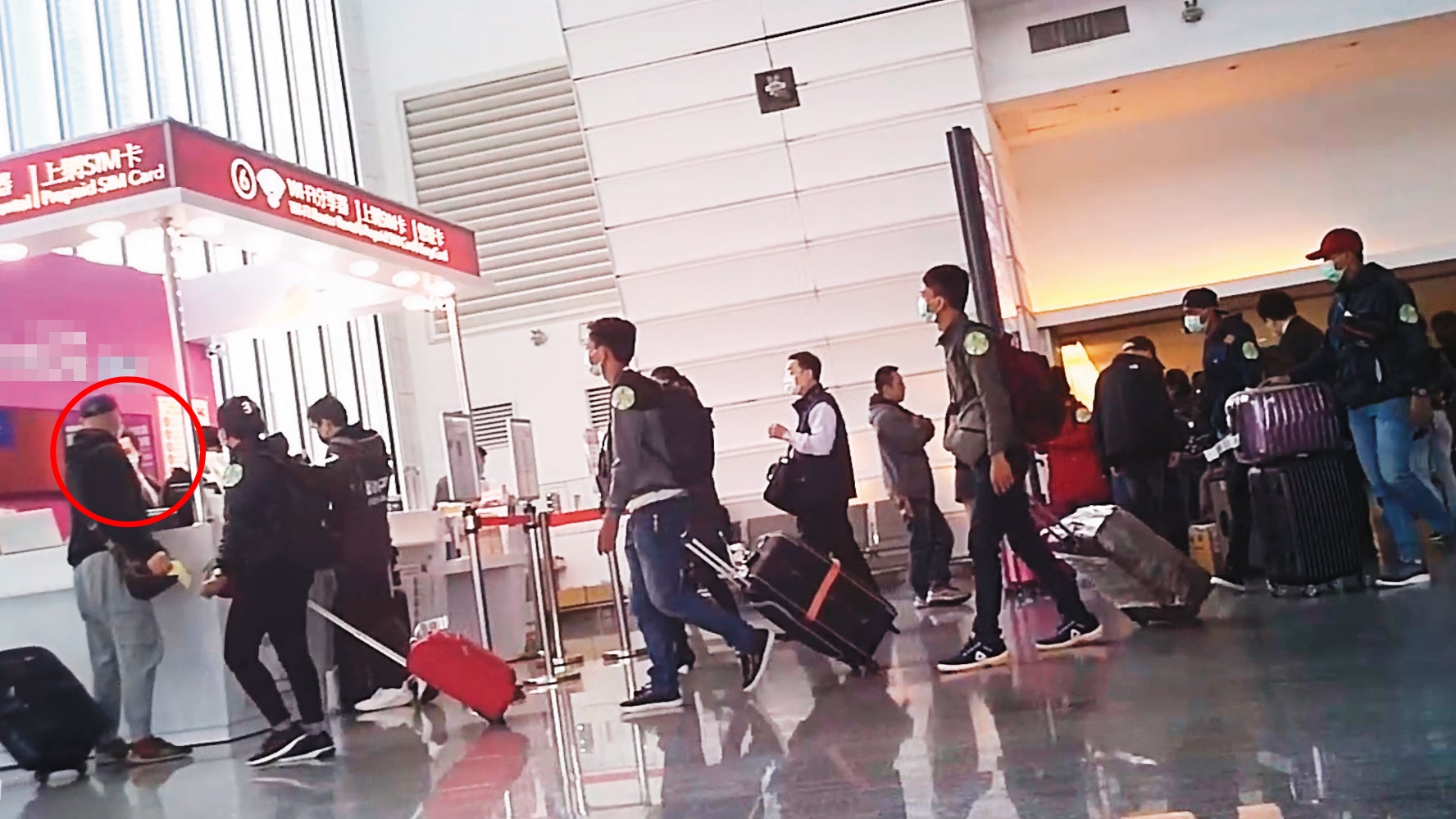 勞動法規講習一結束，移工應該搭車赴健檢中心進行體檢，但健檢中心接機人員（紅圈處）卻在上車前，將他們帶到預付卡代理商櫃台旁集合。