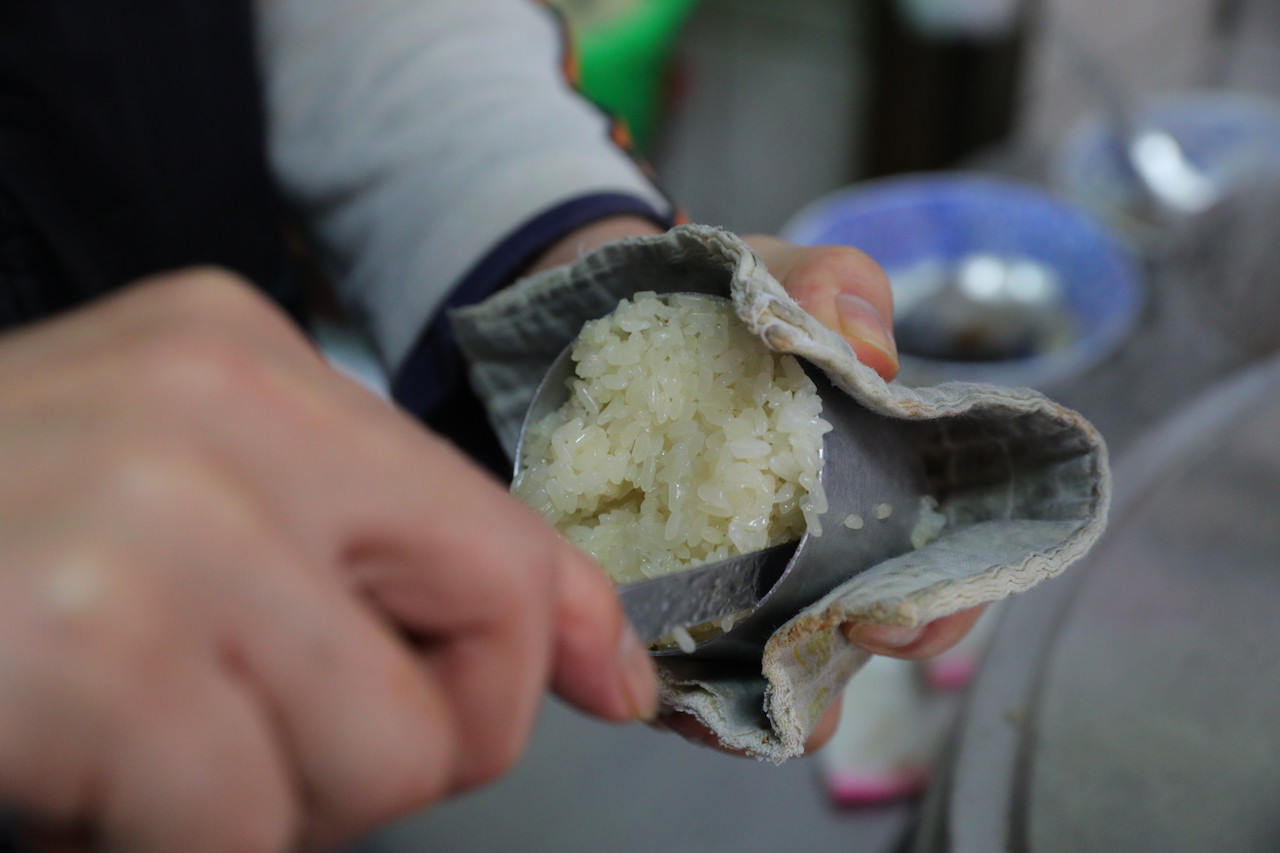 等到客人點餐時，店家才把蒸得熱燙的「米糕」挖出筒罐，倒扣進磁碗。
